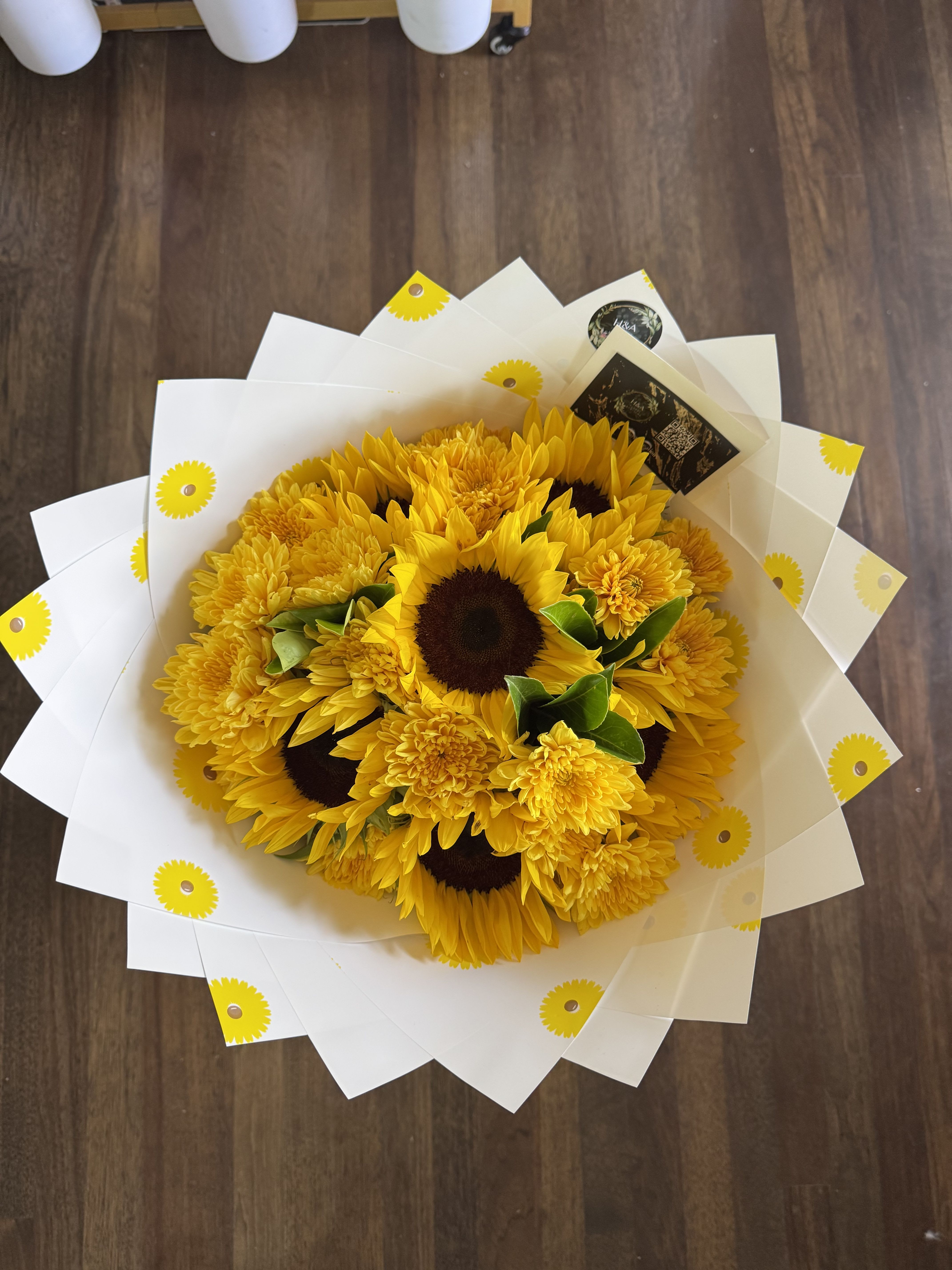 Bouquet of yellow sunflowers and mums wrapped in white paper