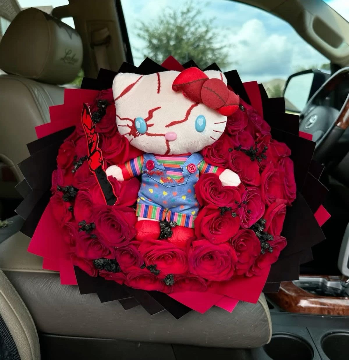 Hello Kitty plush surrounded by red roses in a bouquet