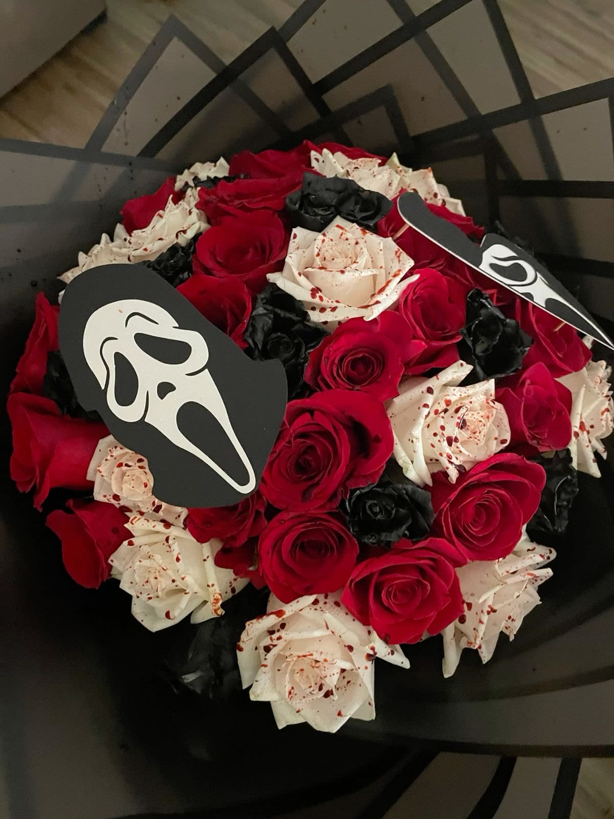 Bouquet of red, white, and black roses with Ghostface toppers