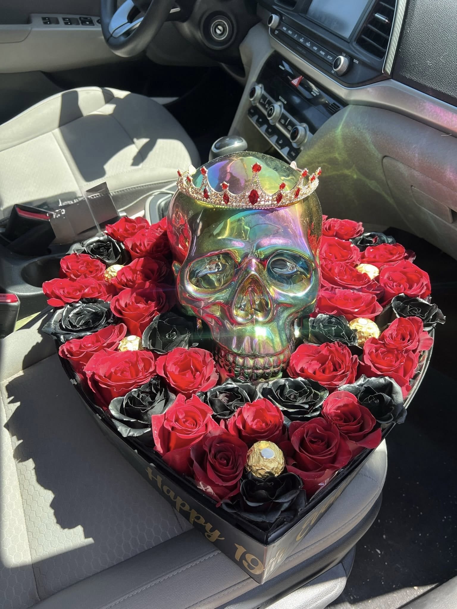Heart-shaped box with roses and a jeweled skull centerpiece