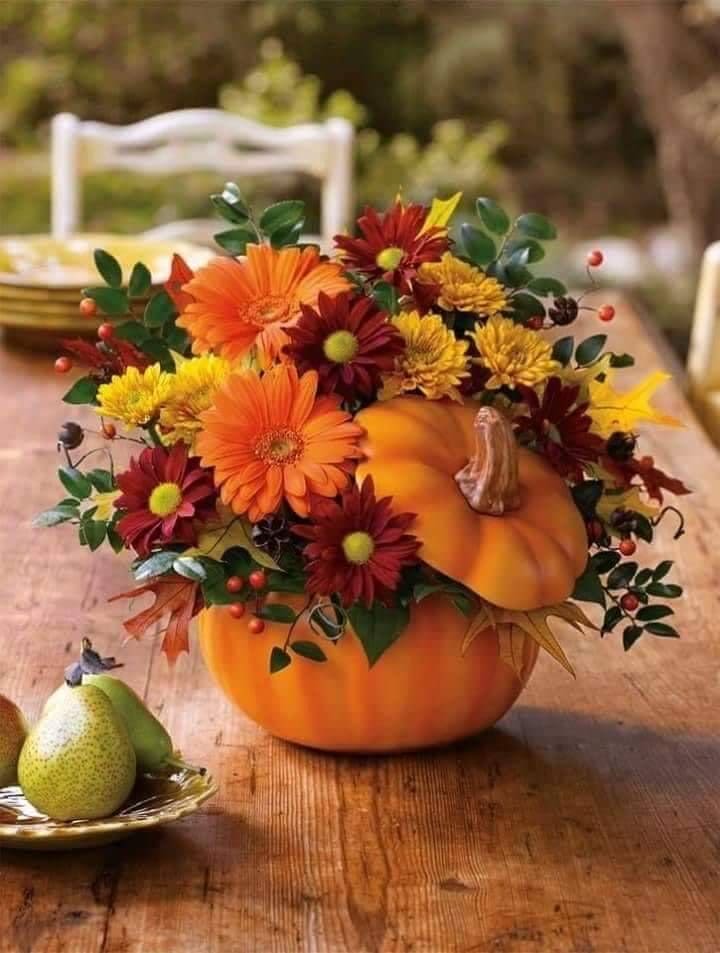 Pumpkin centerpiece with orange and burgundy flowers