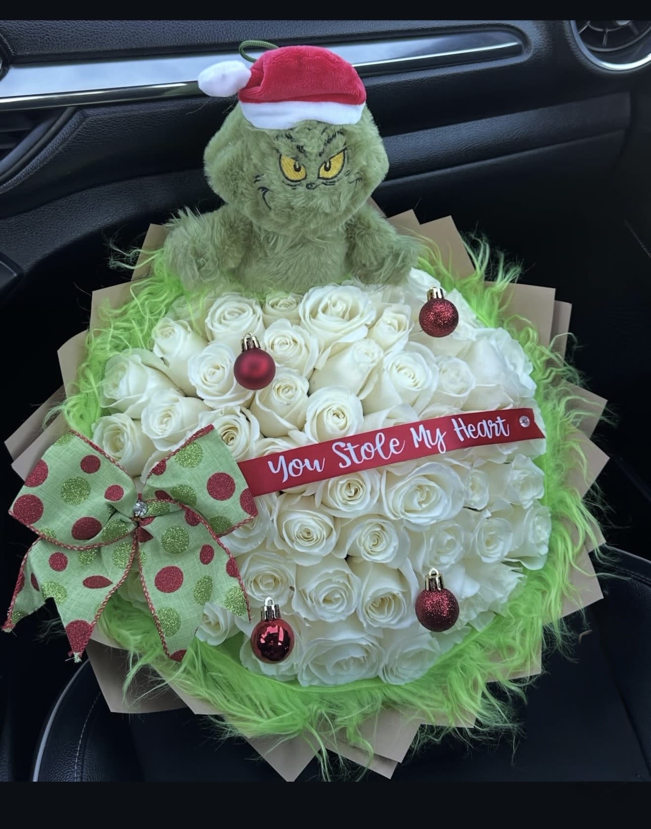 White rose bouquet with a Grinch plush and Christmas ornaments