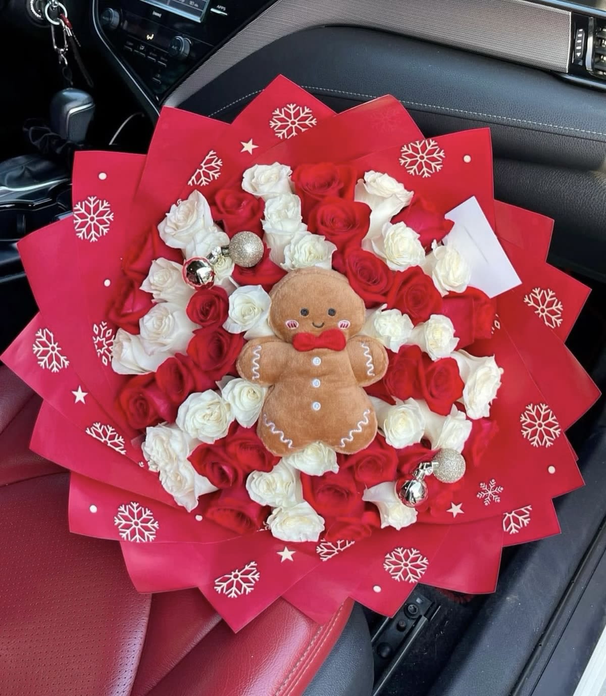 Bouquet of red and white roses with a gingerbread plush in red wrapping