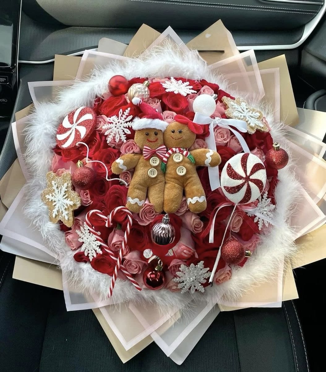 Holiday bouquet with red roses, candy ornaments, and two gingerbread figures