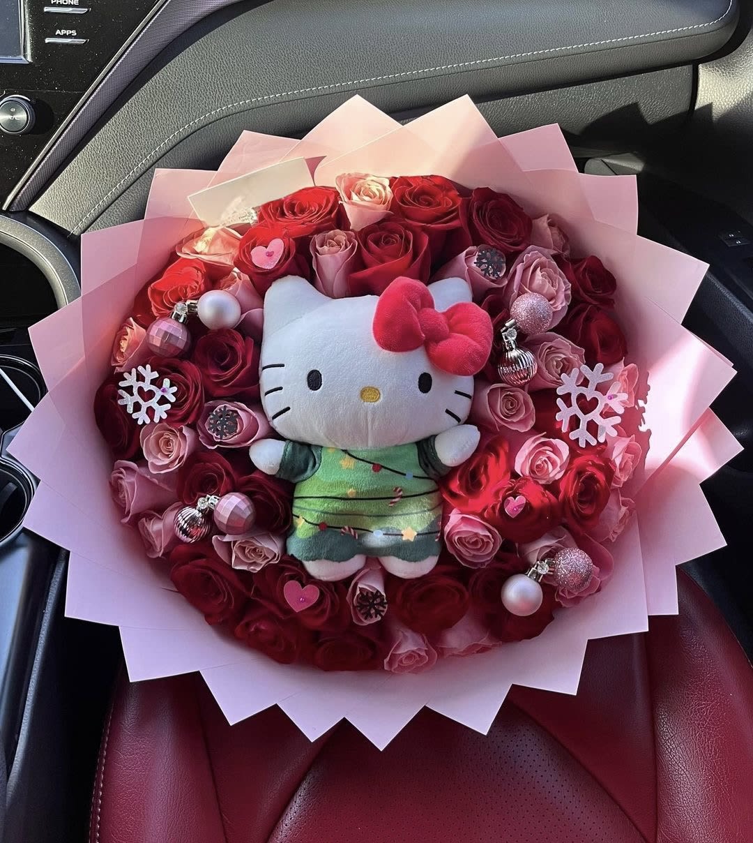 Bouquet of red and pink roses with a Hello Kitty plush in the center