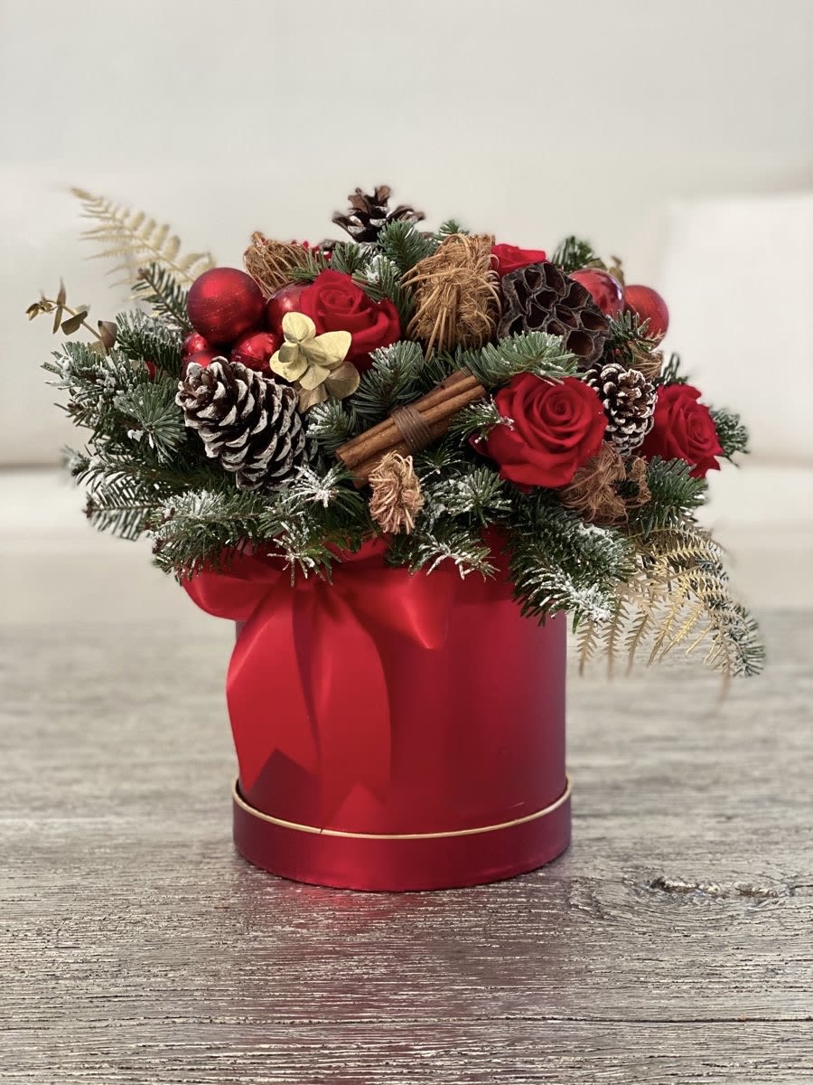 Red roses and pinecones arranged in a red gift box