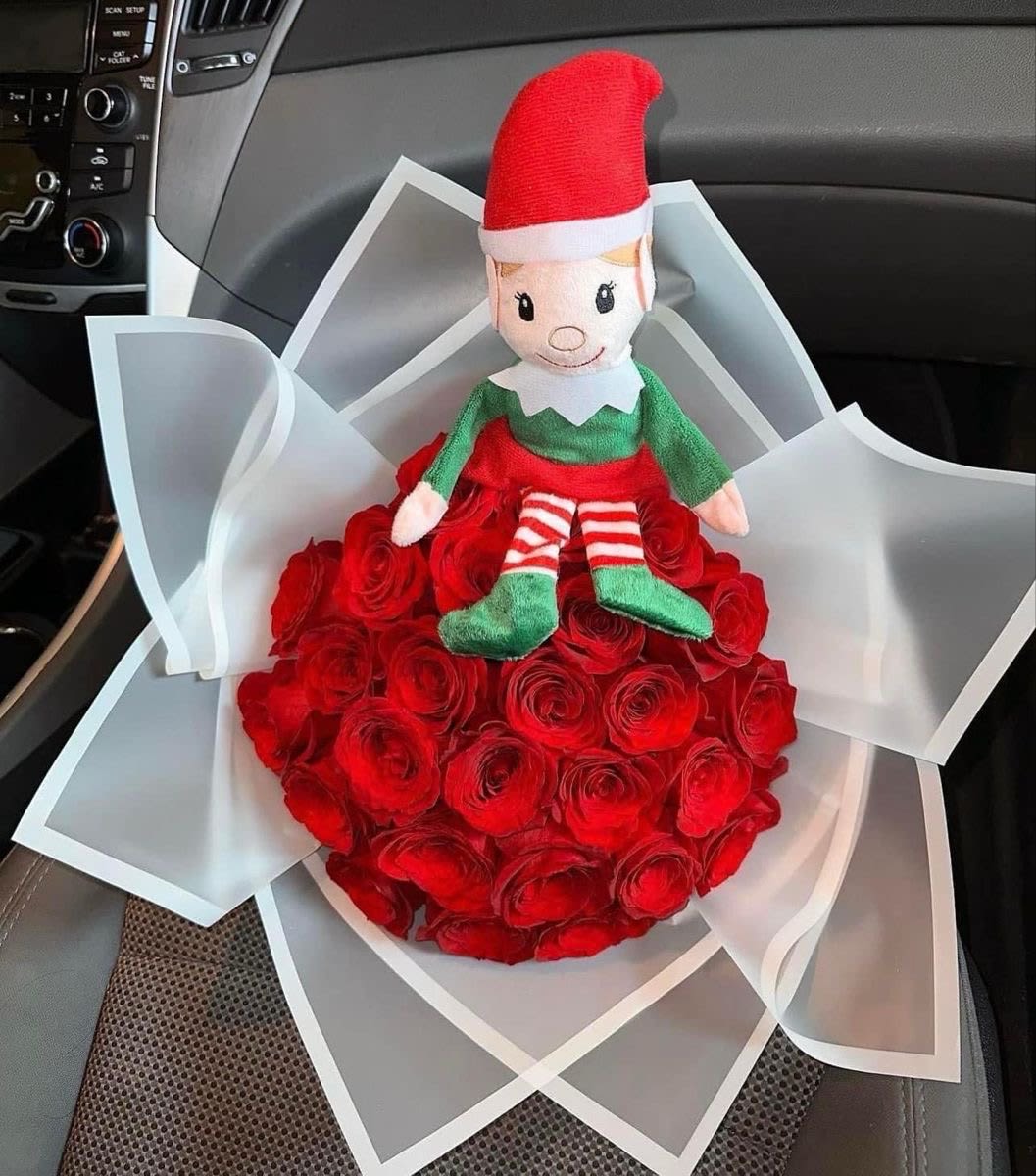 Red rose bouquet with a small elf doll on top