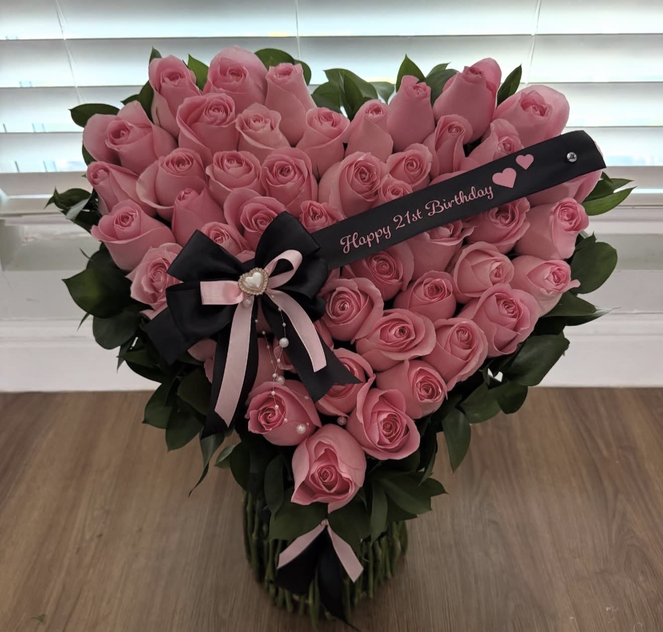 Heart-shaped bouquet of pink roses with a birthday ribbon