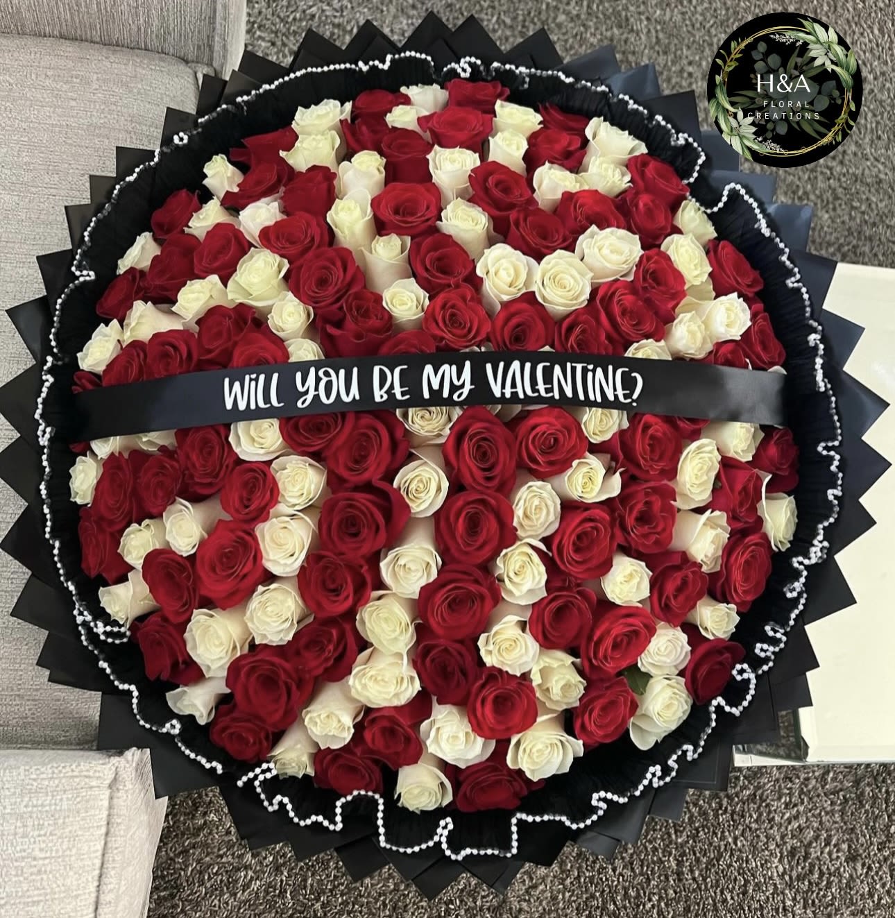 Round bouquet of red and white roses with a Valentine ribbon