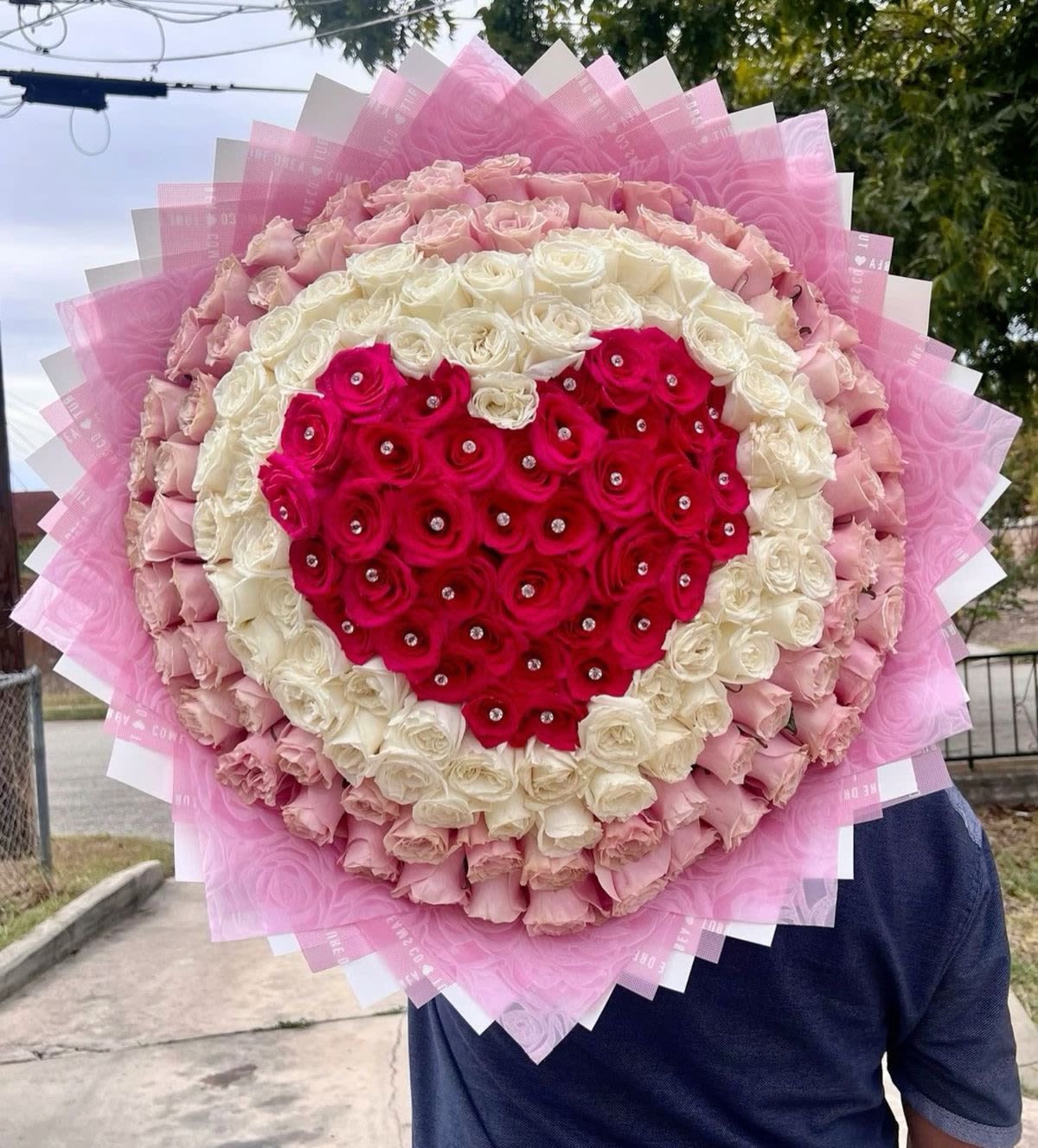 Heart-shaped bouquet of pink and white roses with a red rose center