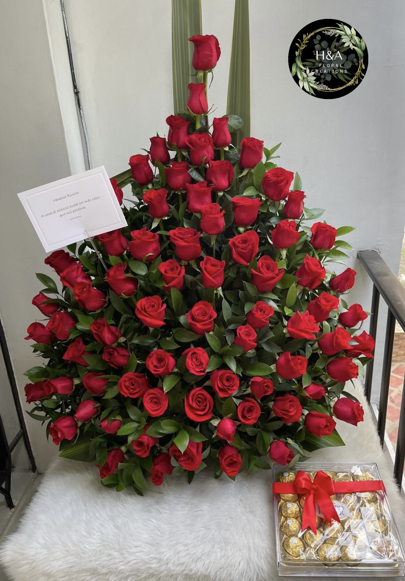 Large arrangement of red roses with a box of chocolates