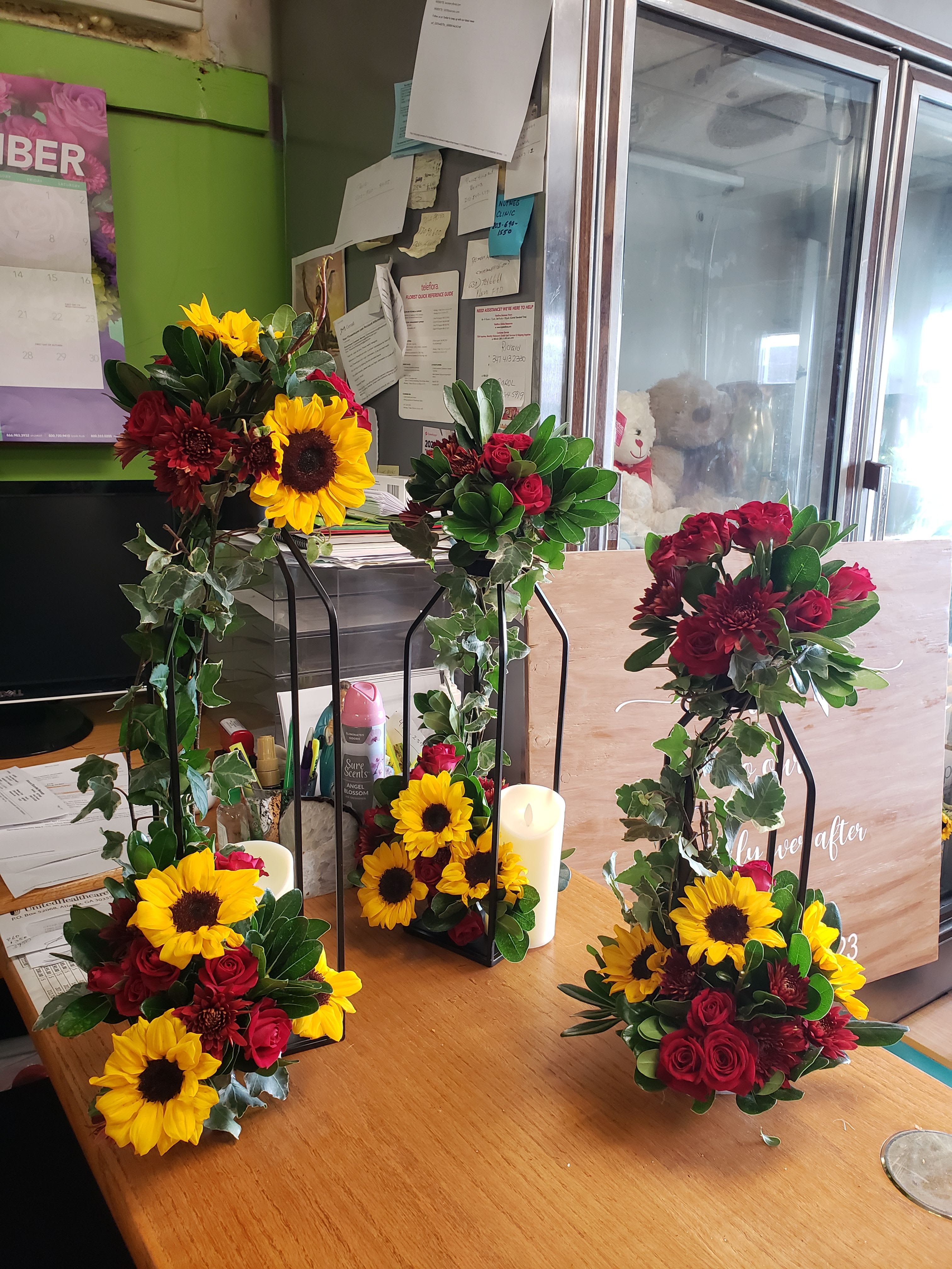 Wedding floral arrangements with sunflowers and red roses on black stands