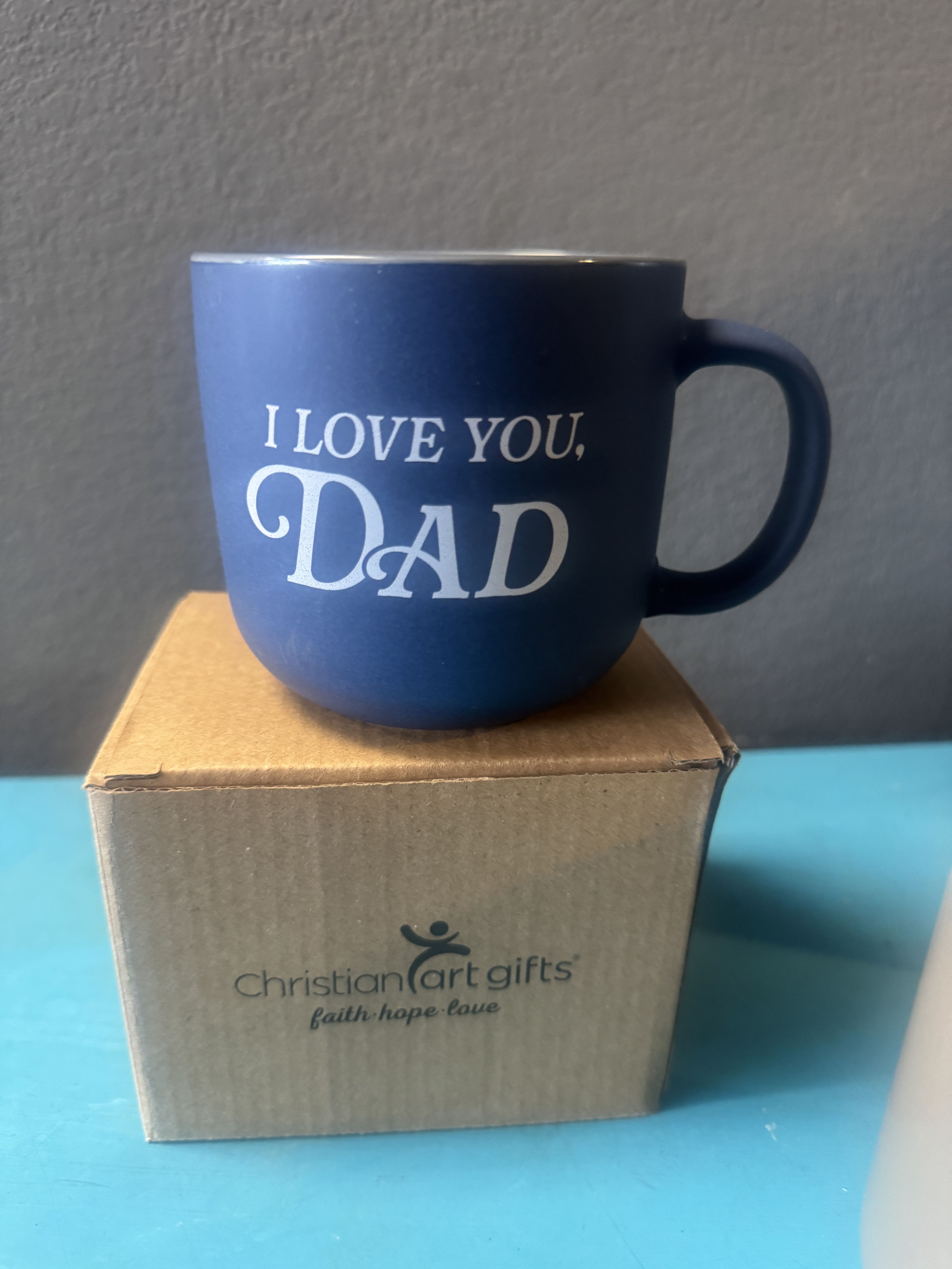 Blue mug with "I LOVE YOU, DAD" text on a cardboard box