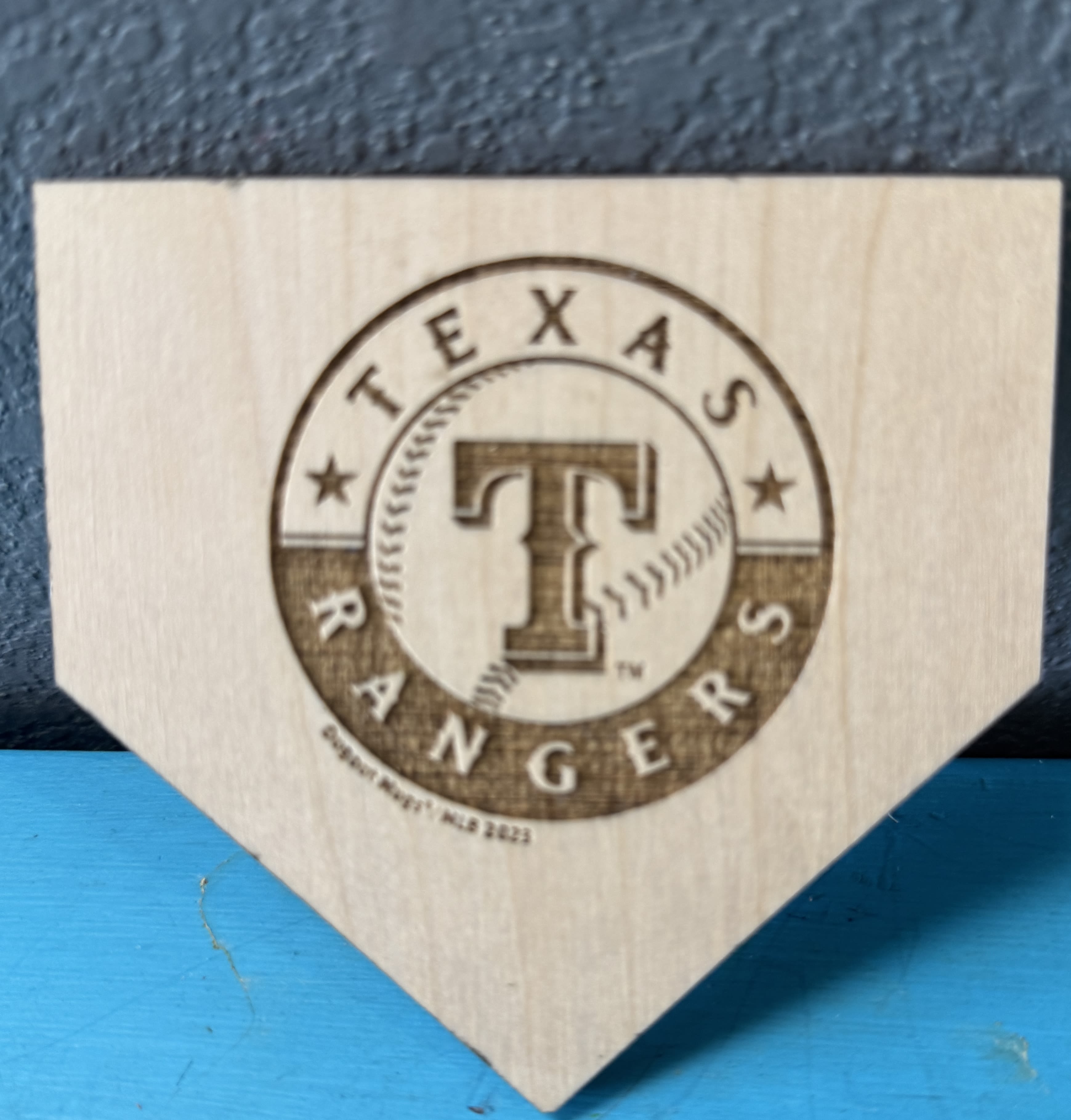Texas Rangers logo on a wooden plaque