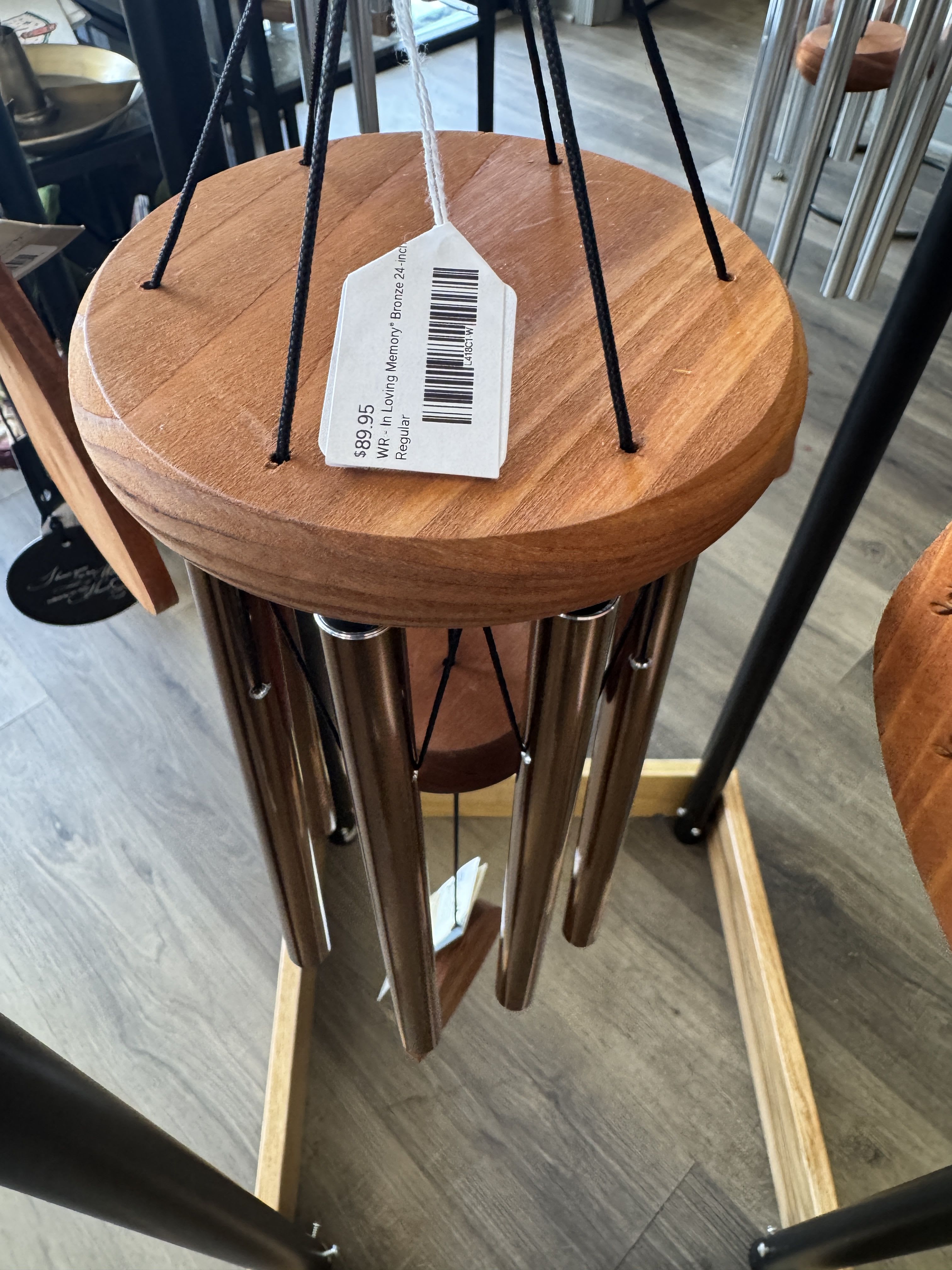 Wooden wind chime with metal tubes and a hanging price tag