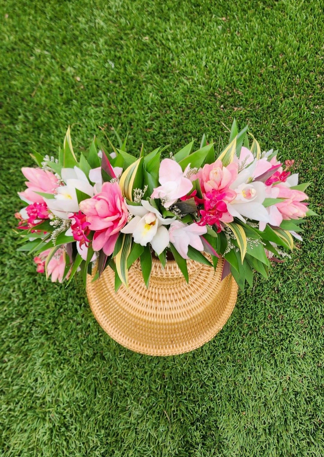 Pink and white floral arrangement in a woven basket