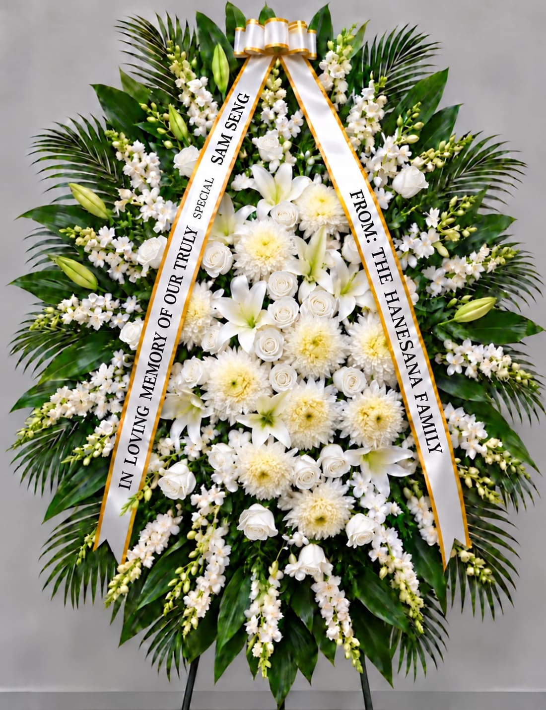 White funeral wreath with ribbon tribute and mixed blooms