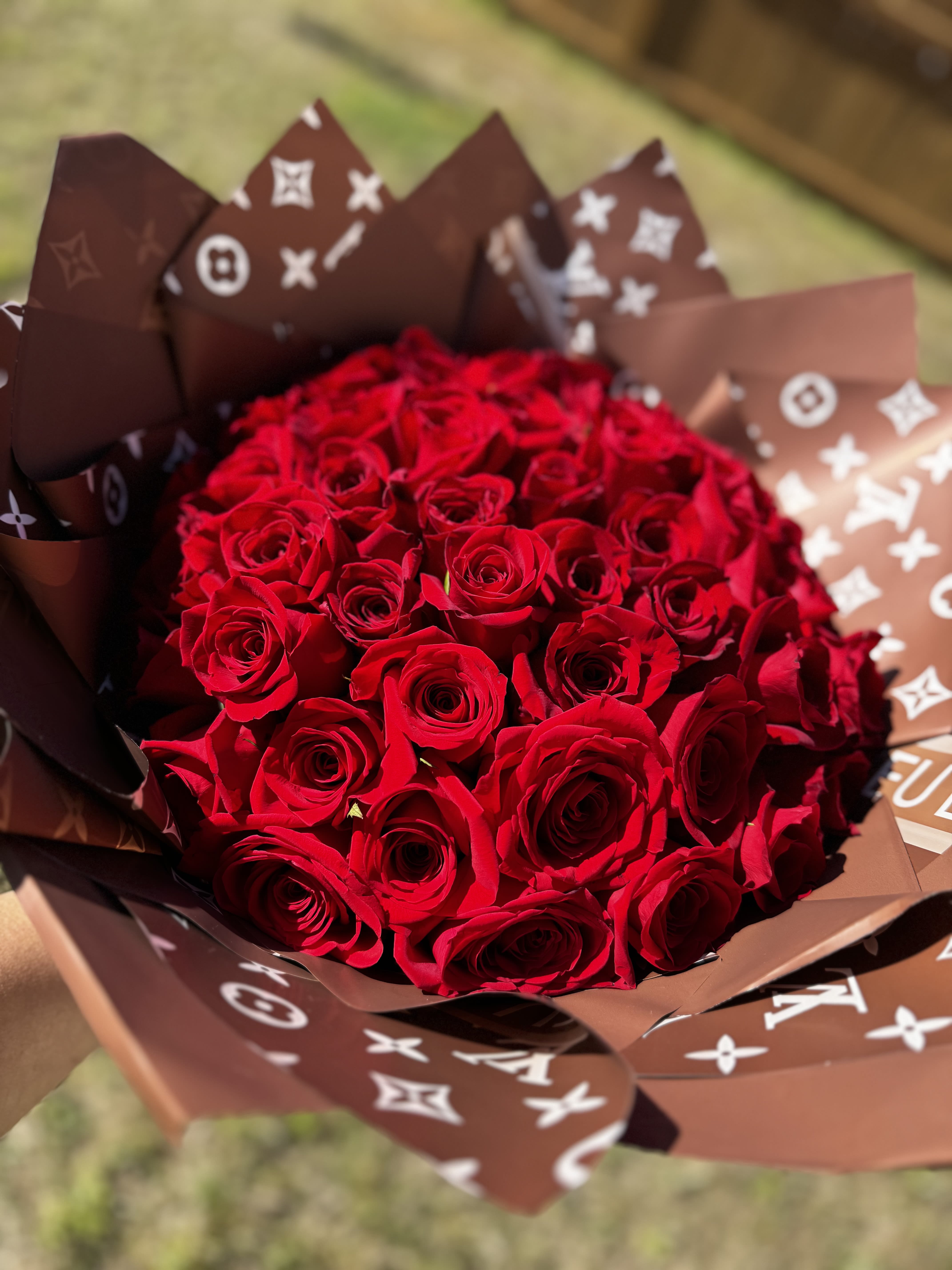 Bouquet of red roses wrapped in brown patterned paper