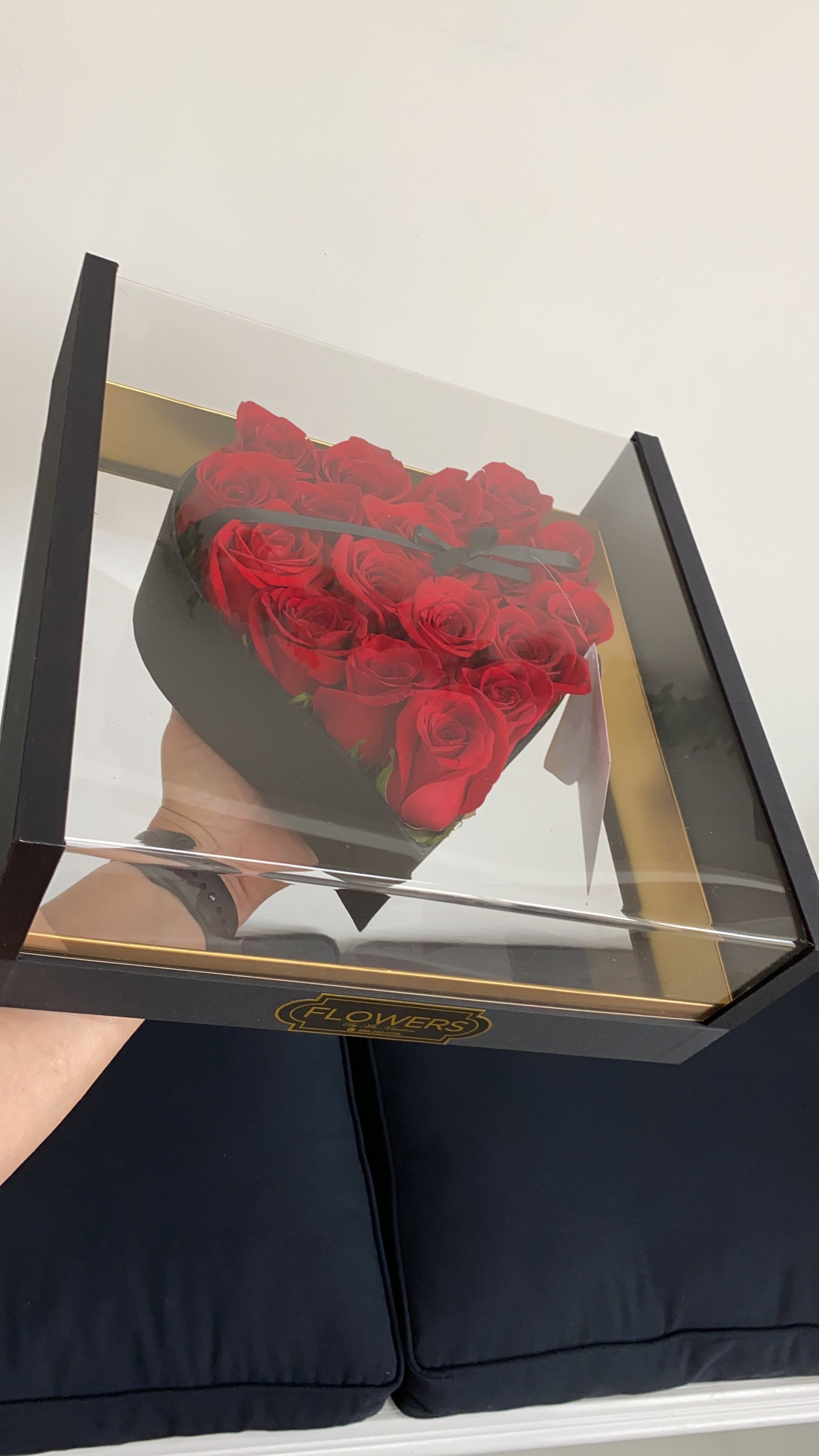 Heart-shaped box of red roses under a clear lid