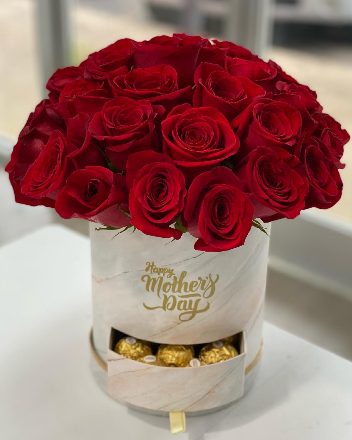 Red rose bouquet in a white box with chocolates
