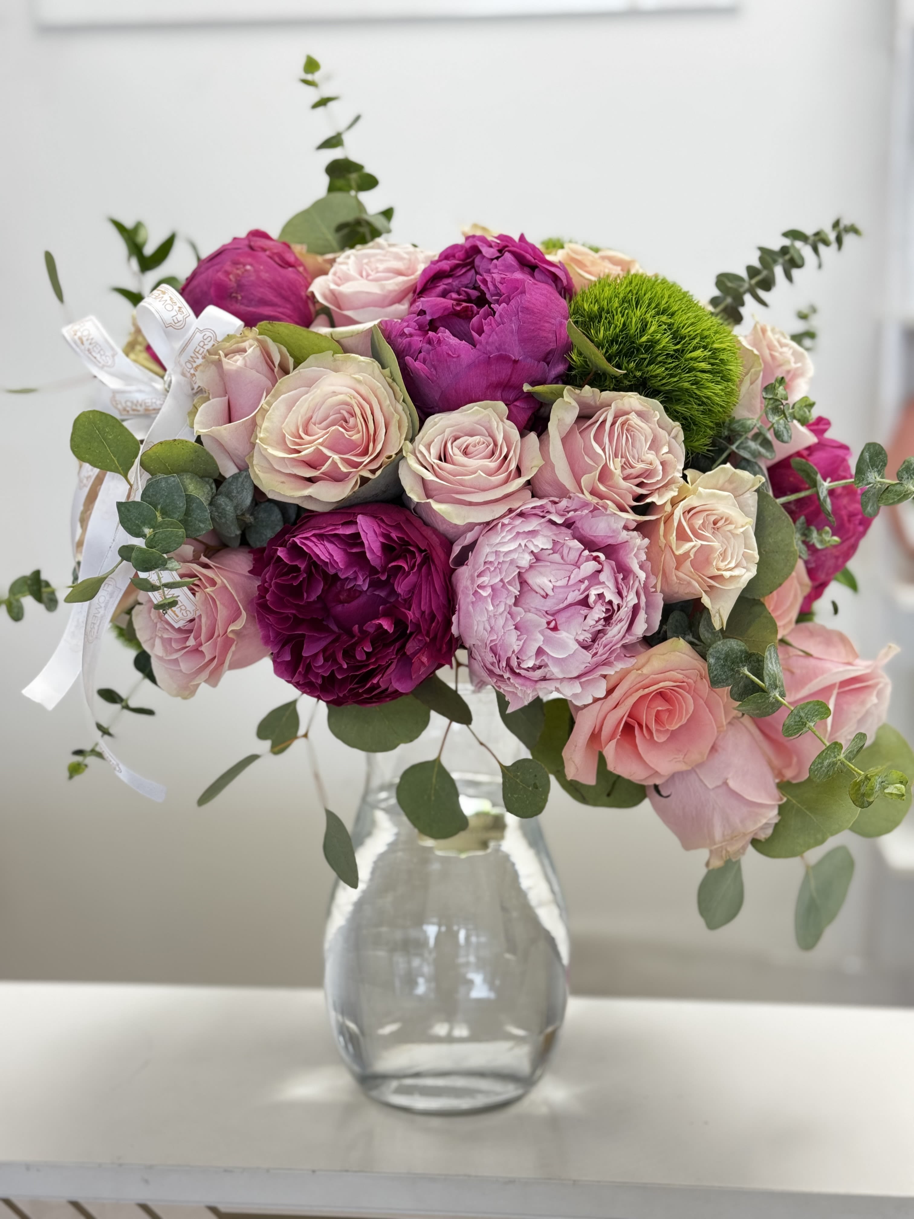 Pink and magenta rose bouquet in a clear glass vase