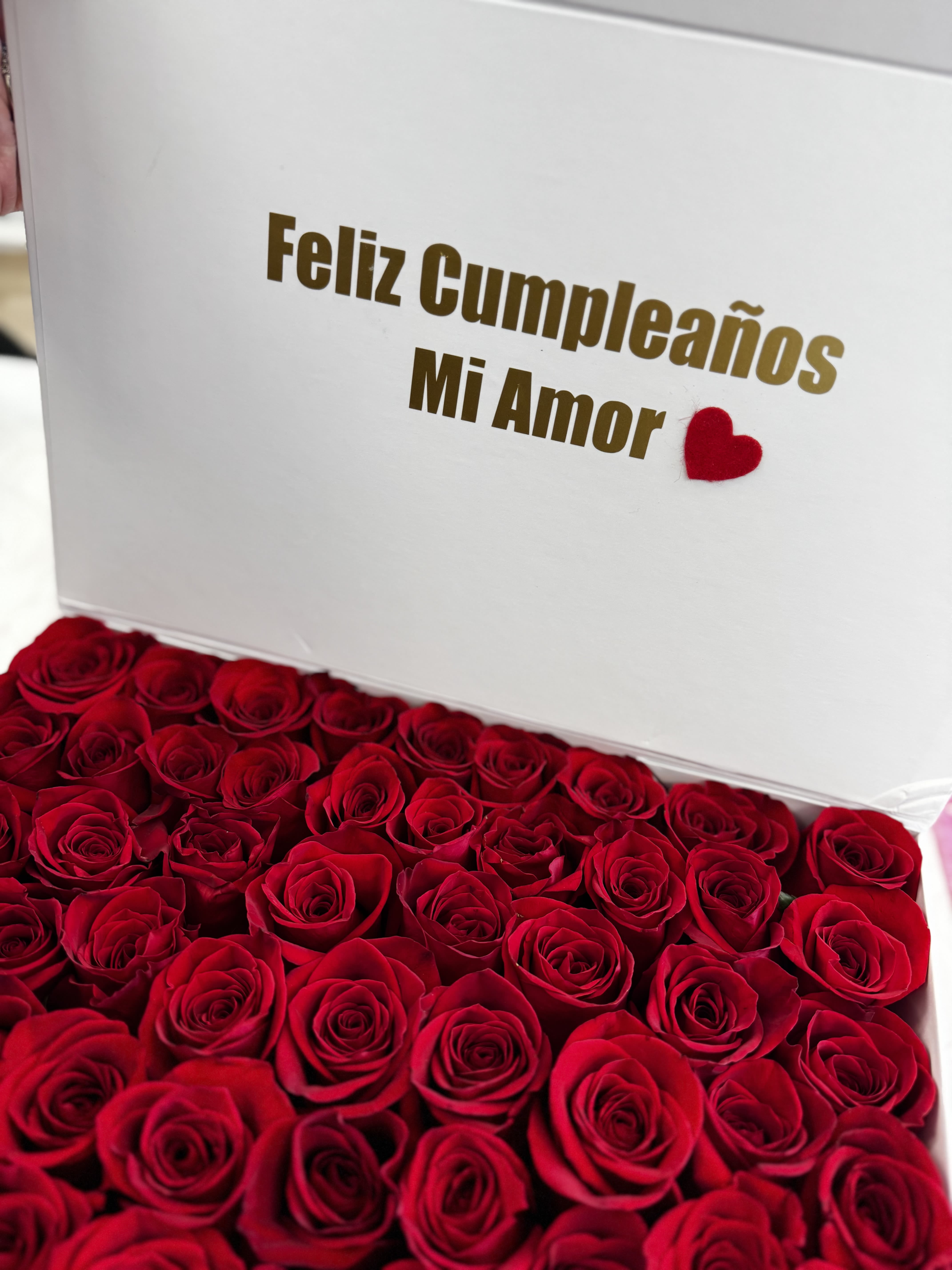 Box of red roses with a "Feliz Cumpleaños Mi Amor" message