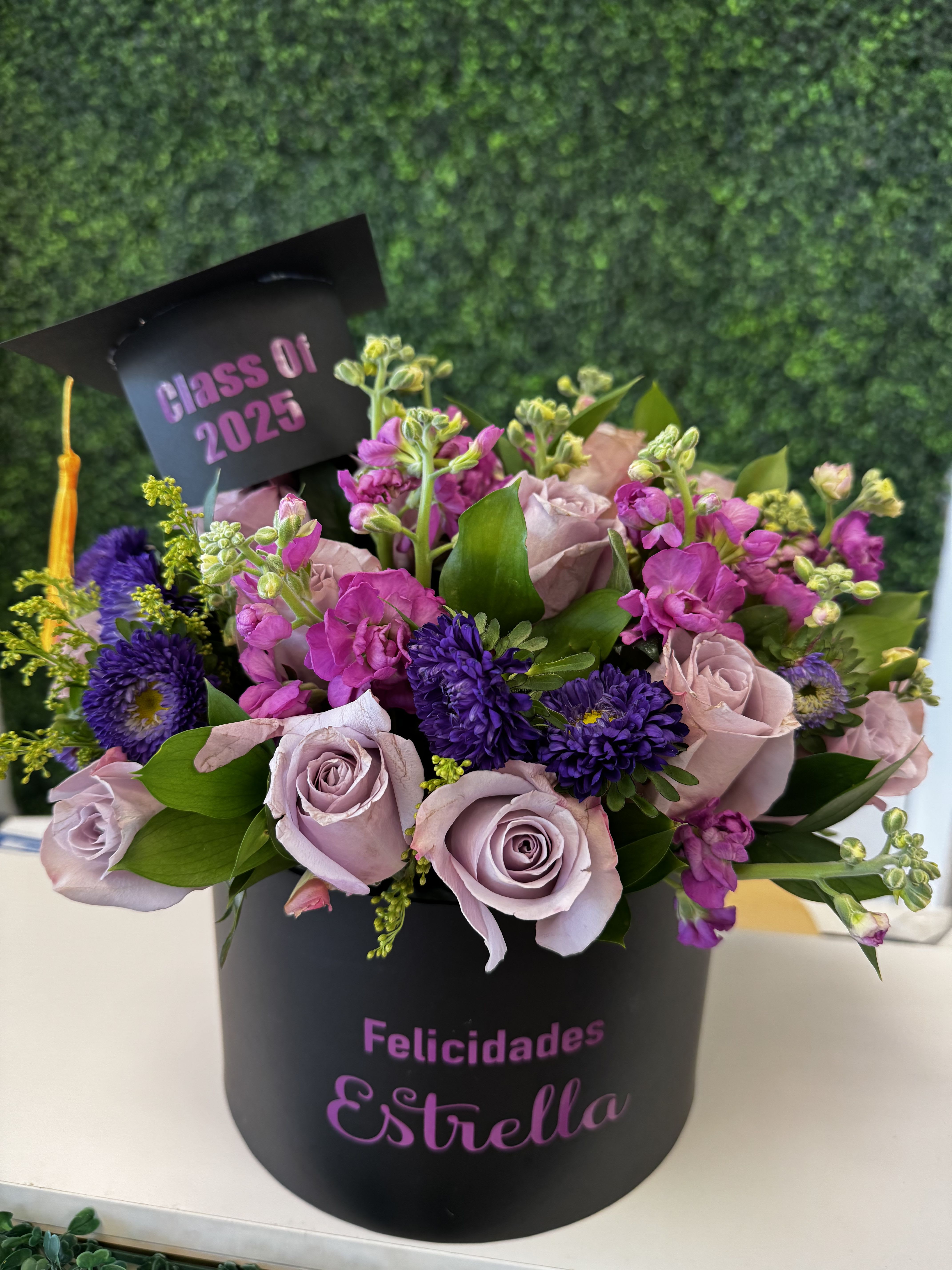 Lavender roses and purple flowers in a black graduation box