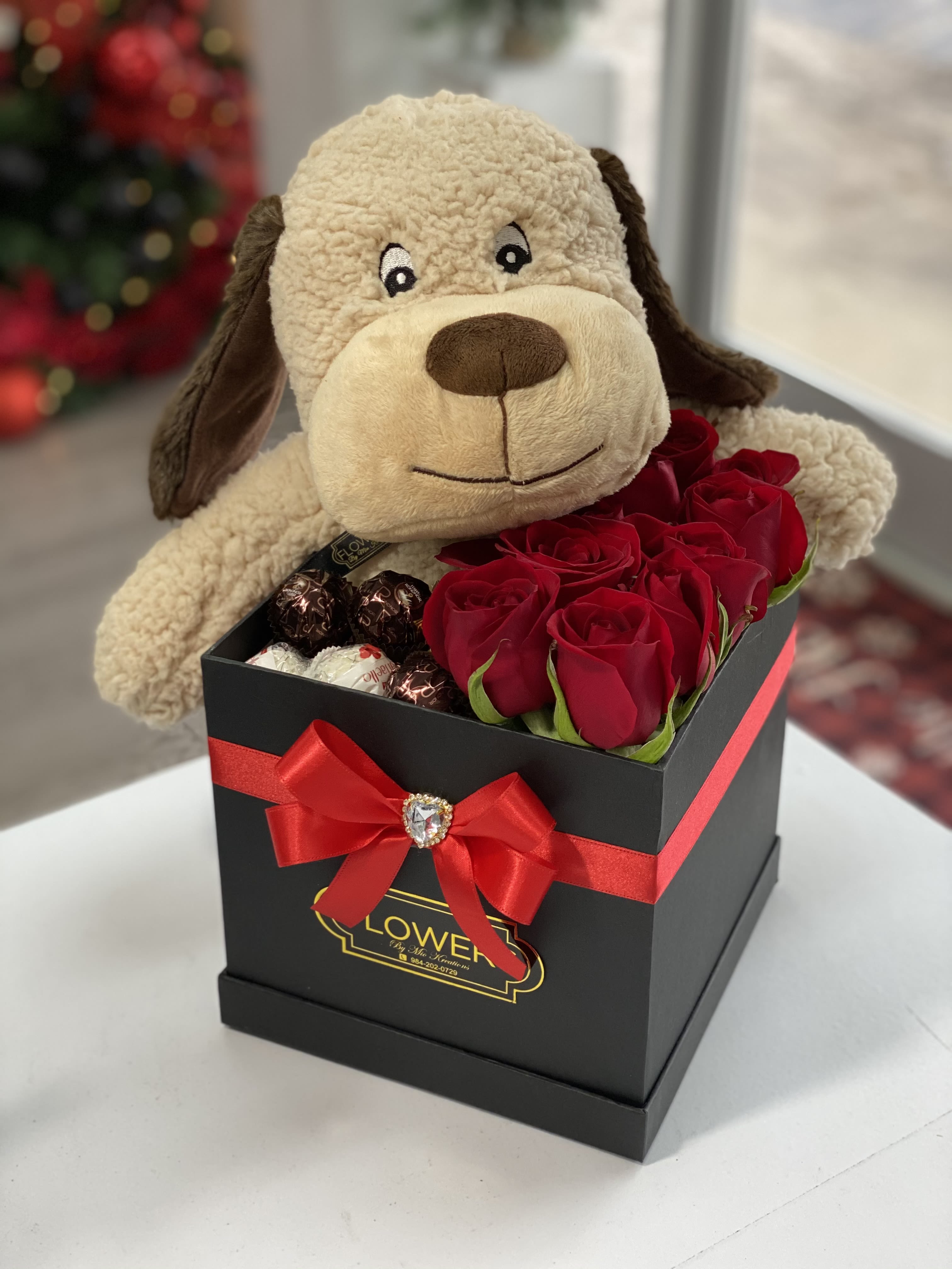 Plush dog in a black gift box with red roses and chocolates