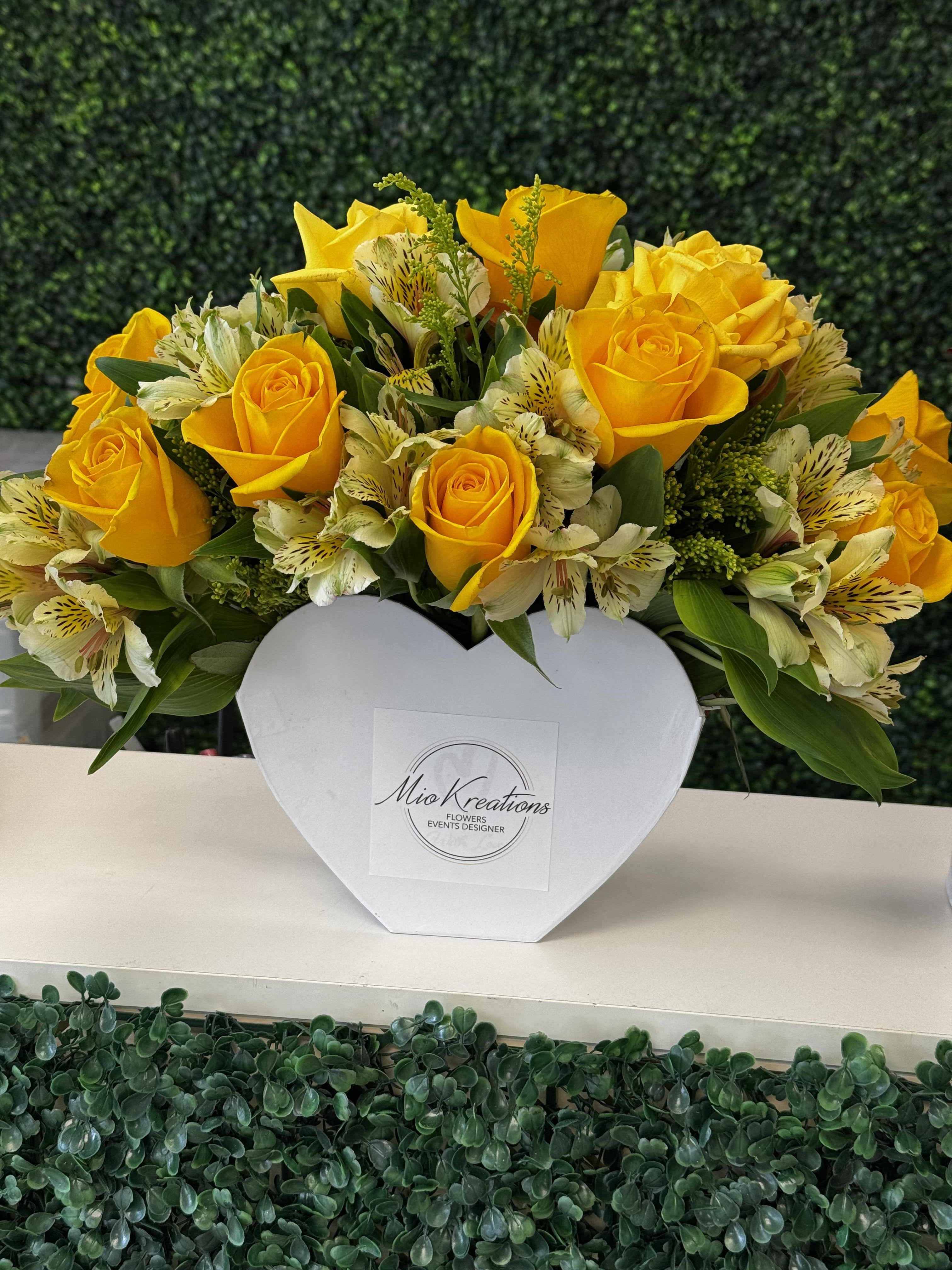 Yellow roses and white alstroemeria in a white heart-shaped box