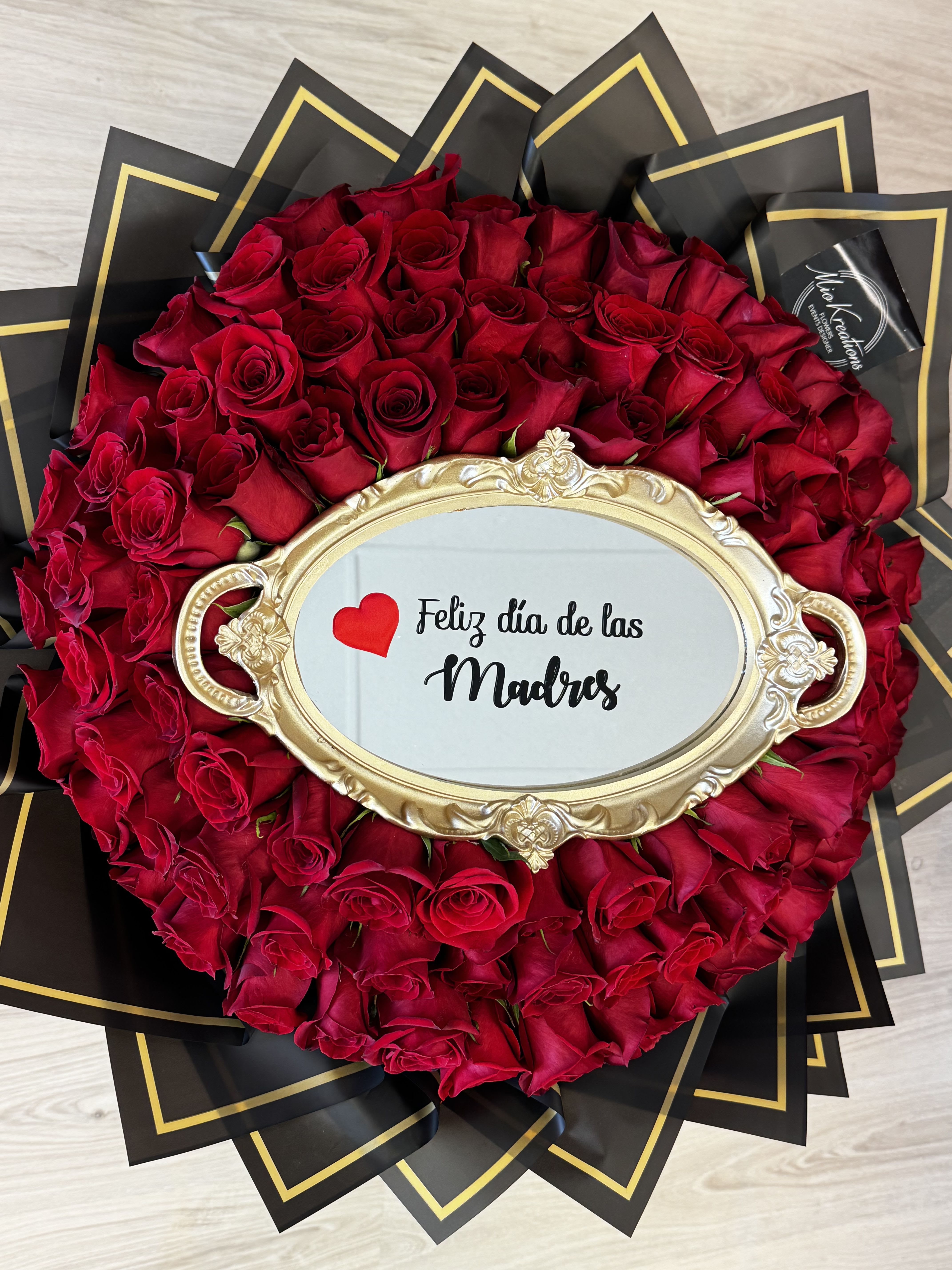 Round bouquet of red roses with a gold-framed Mother's Day sign