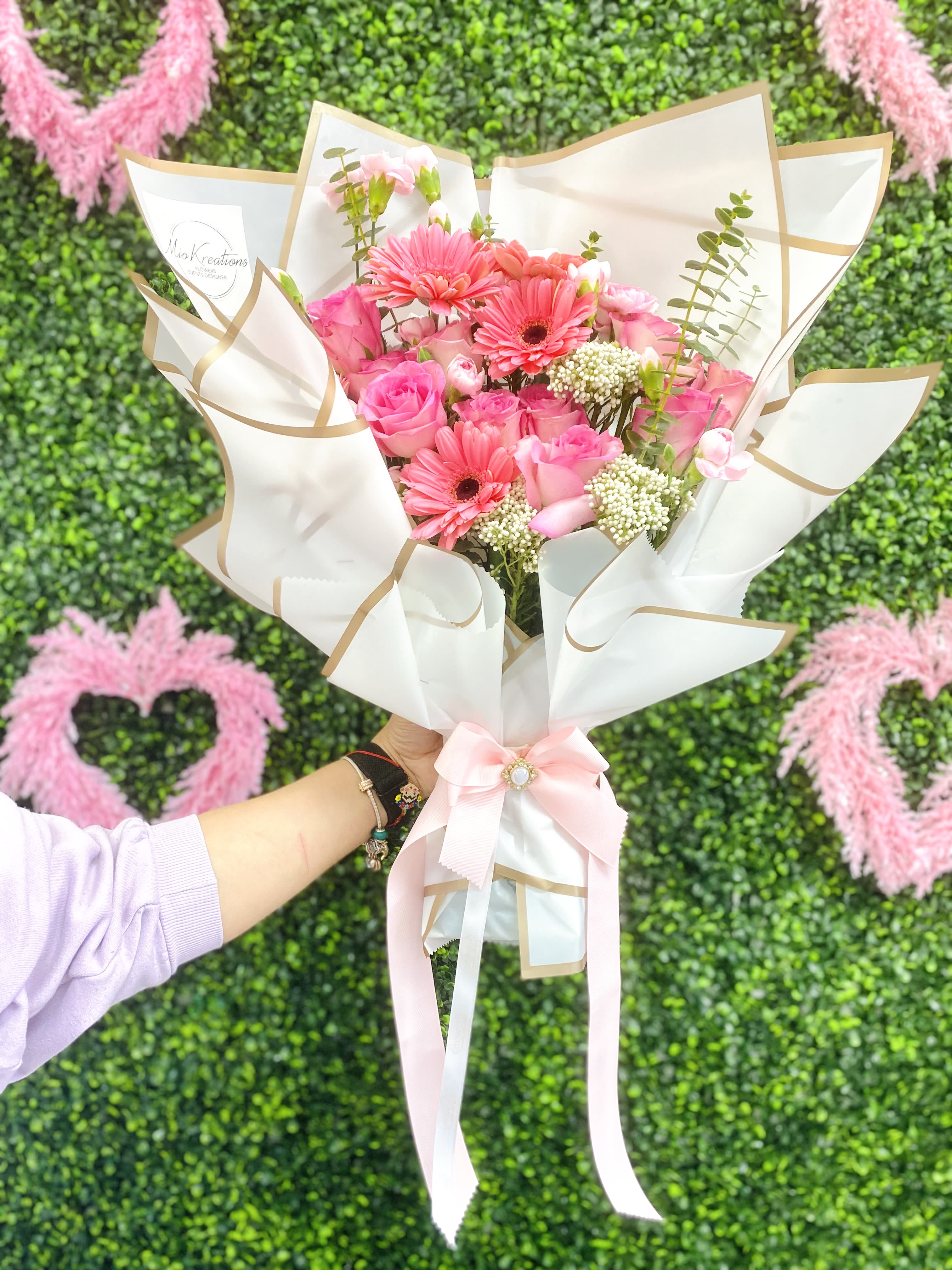 Pink bouquet with roses and gerbera daisies wrapped in white paper