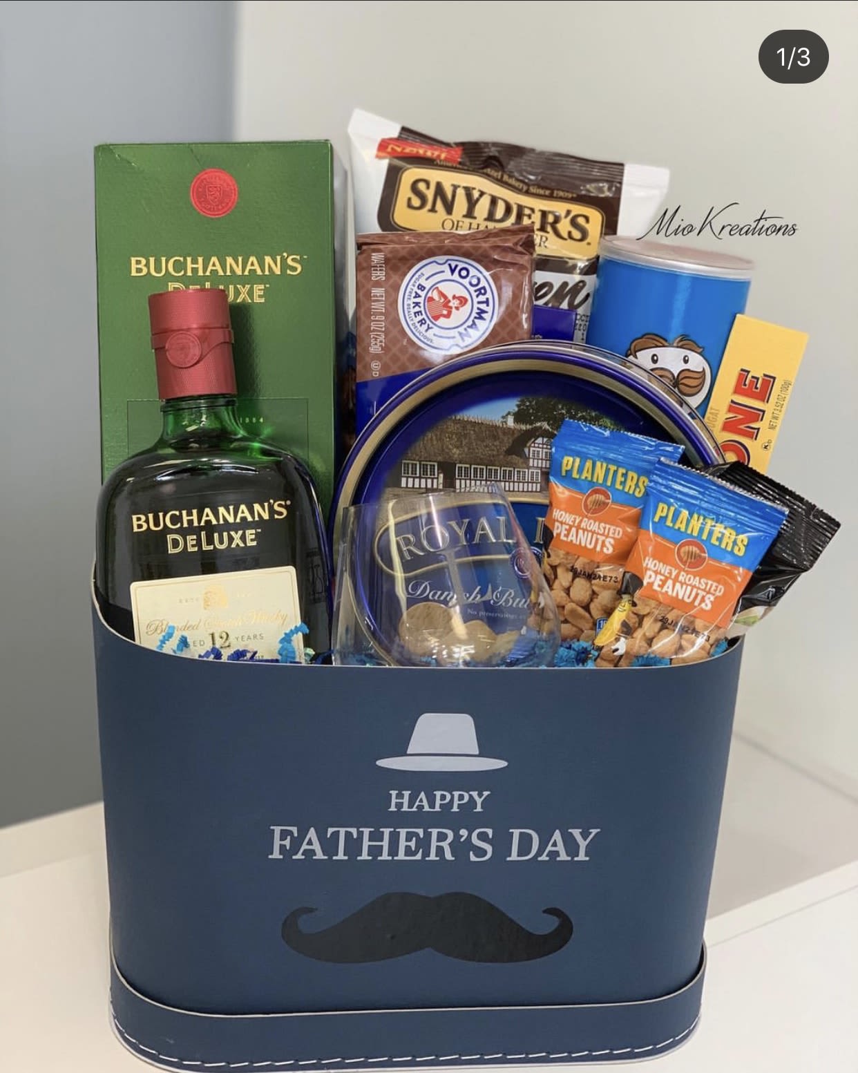 Father's Day gift basket with whiskey, snacks, and a blue box