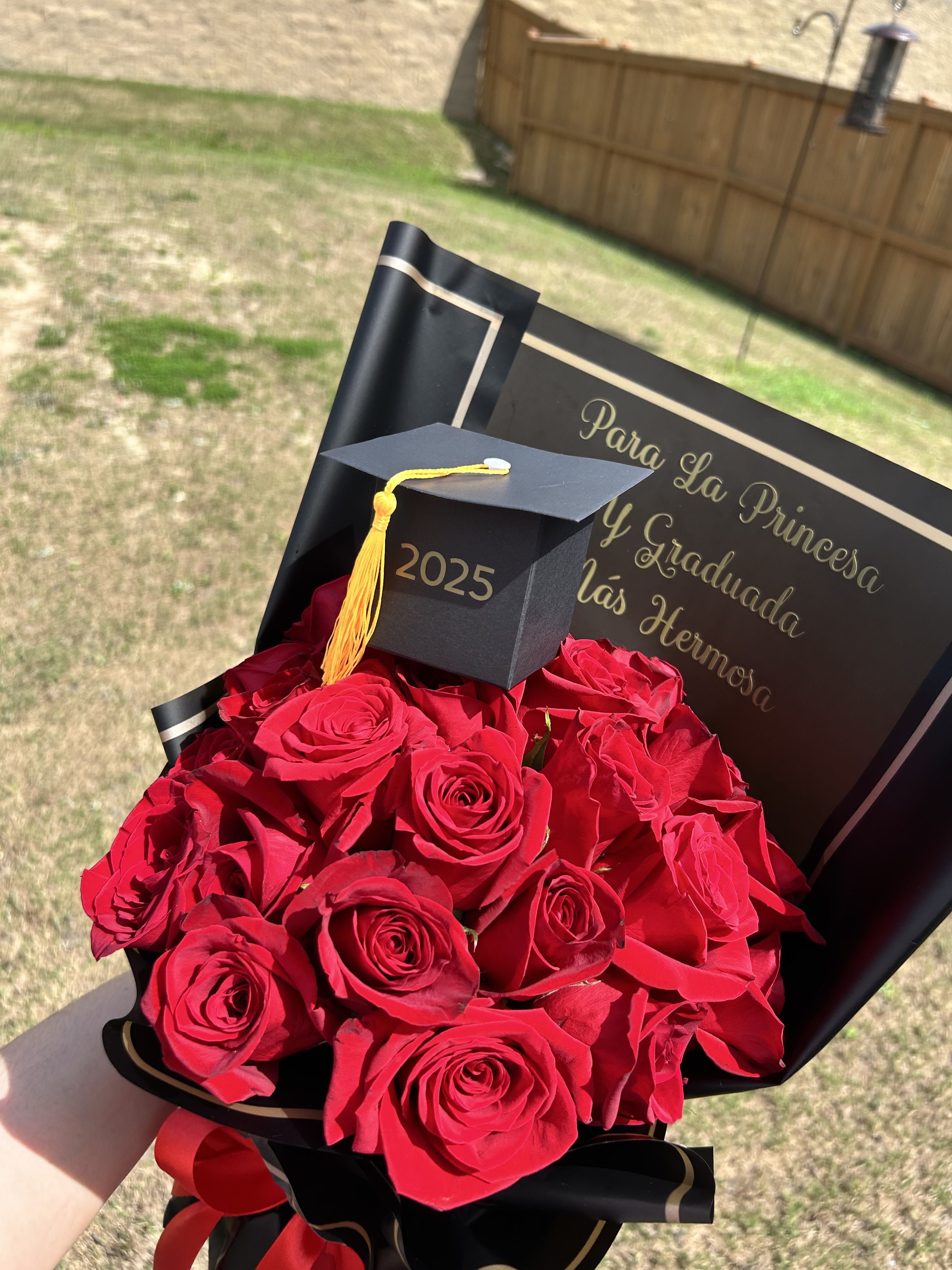 Bouquet of red roses with a graduation cap and card