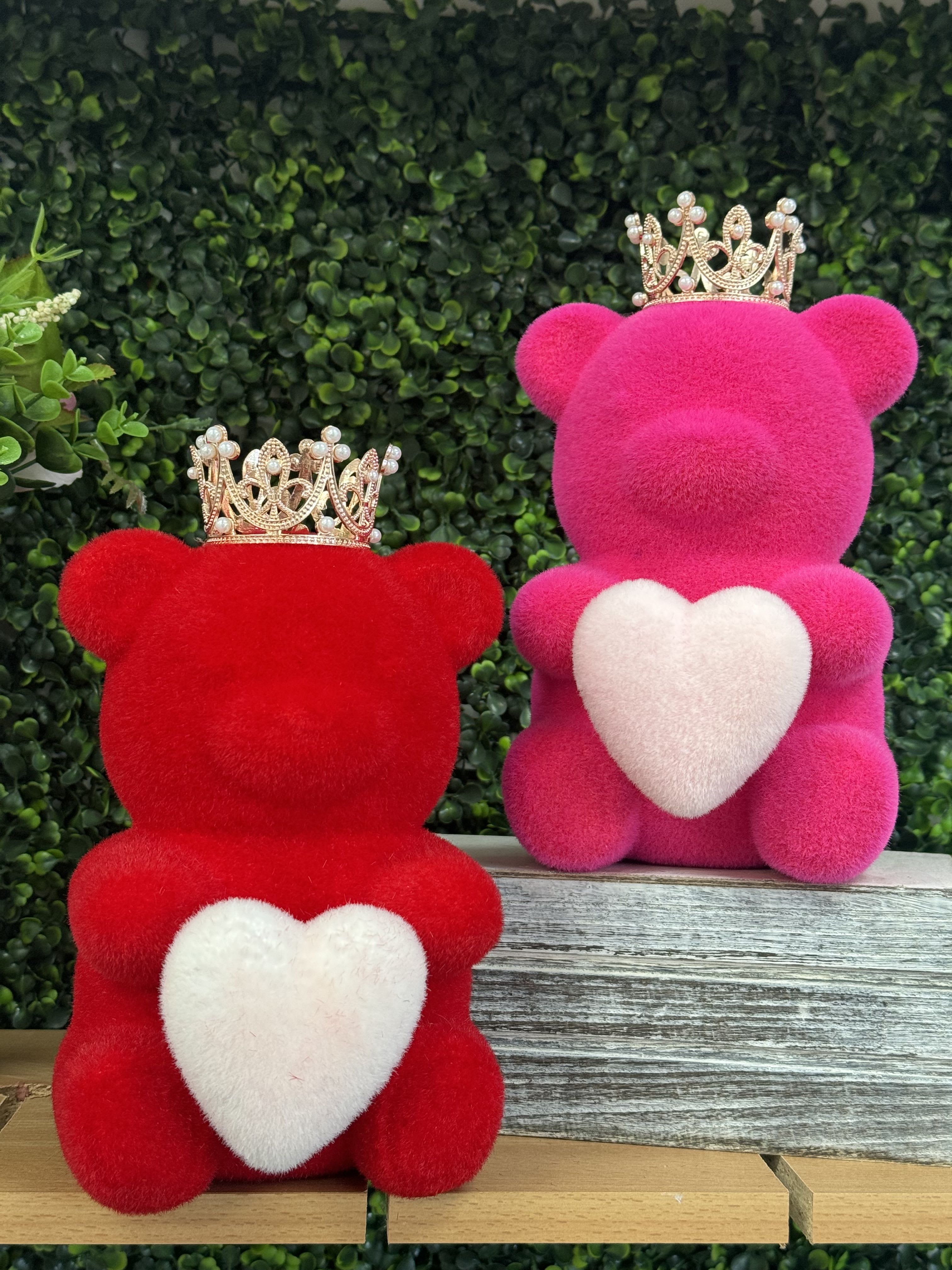 Two plush teddy bears with crowns and heart patches, one red and one pink