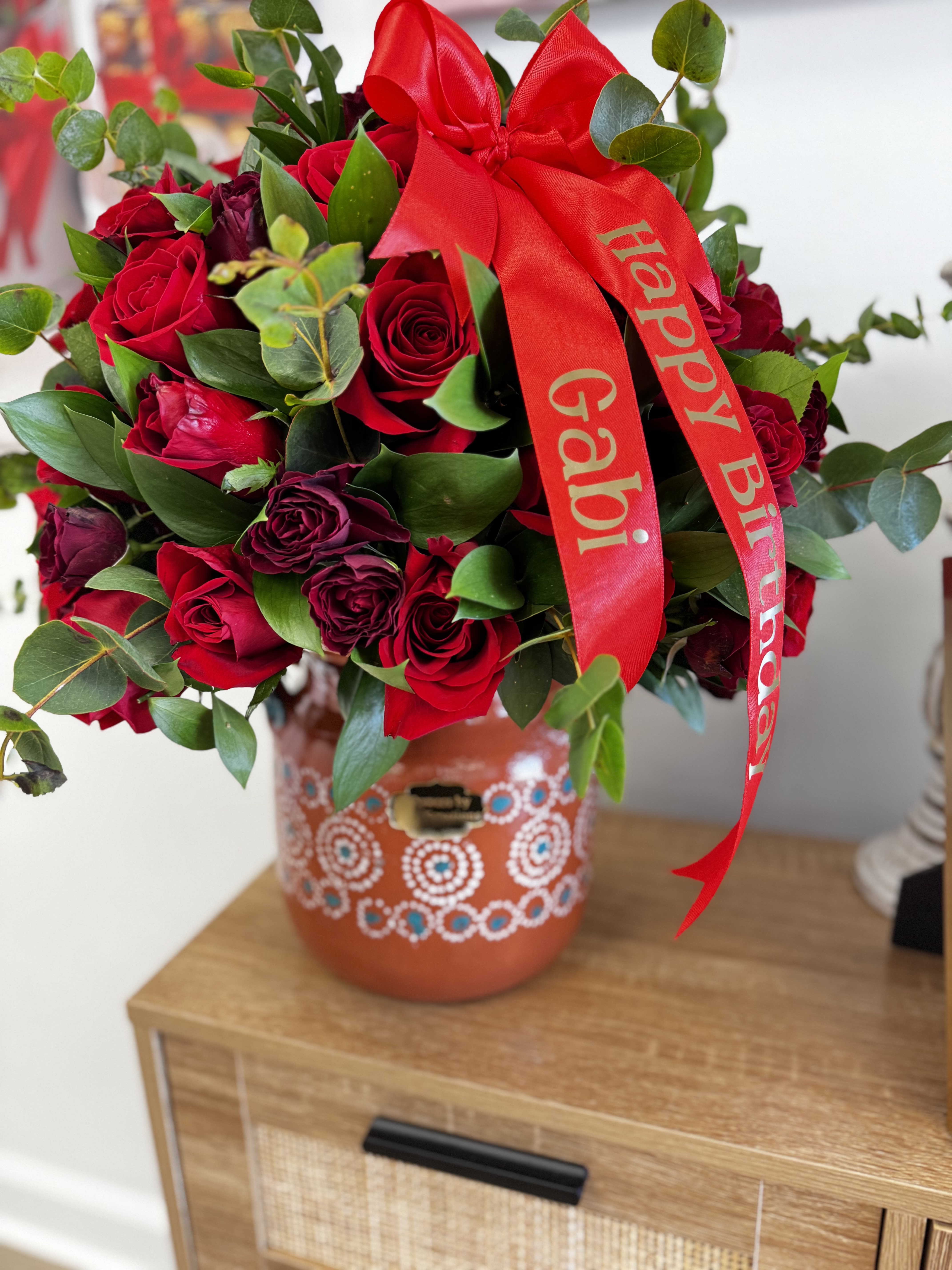 Red rose bouquet with a birthday ribbon in a decorated vase