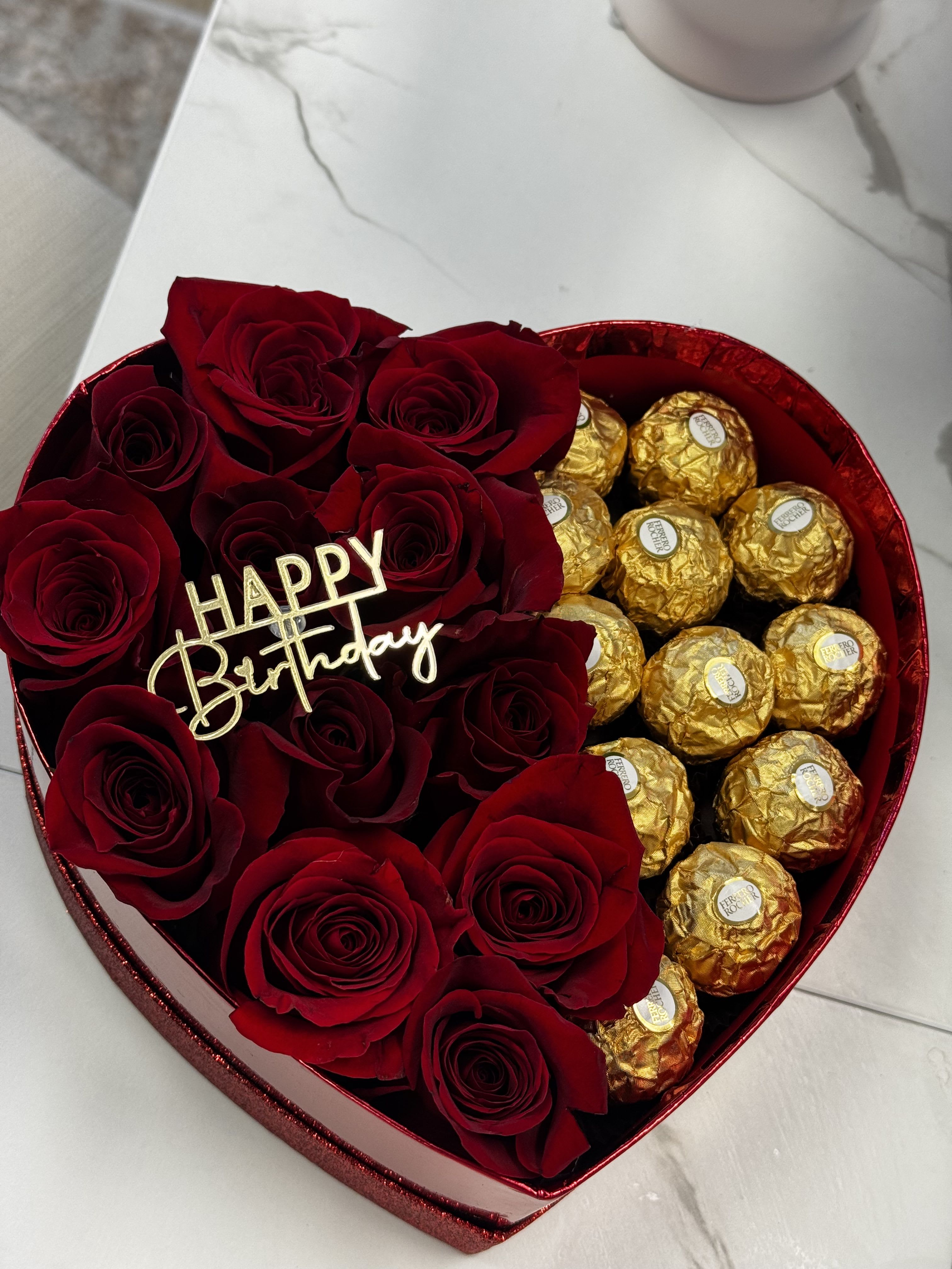 Heart-shaped box with red roses and gold-wrapped chocolates