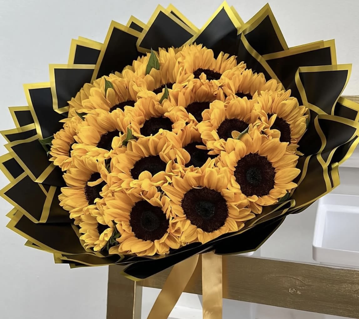Bouquet of sunflowers wrapped in black and gold paper