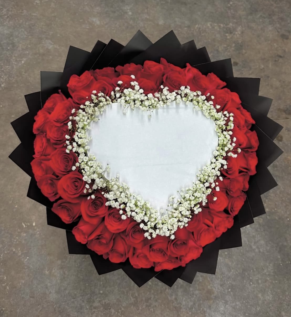 Heart-shaped bouquet of red roses with white baby's breath
