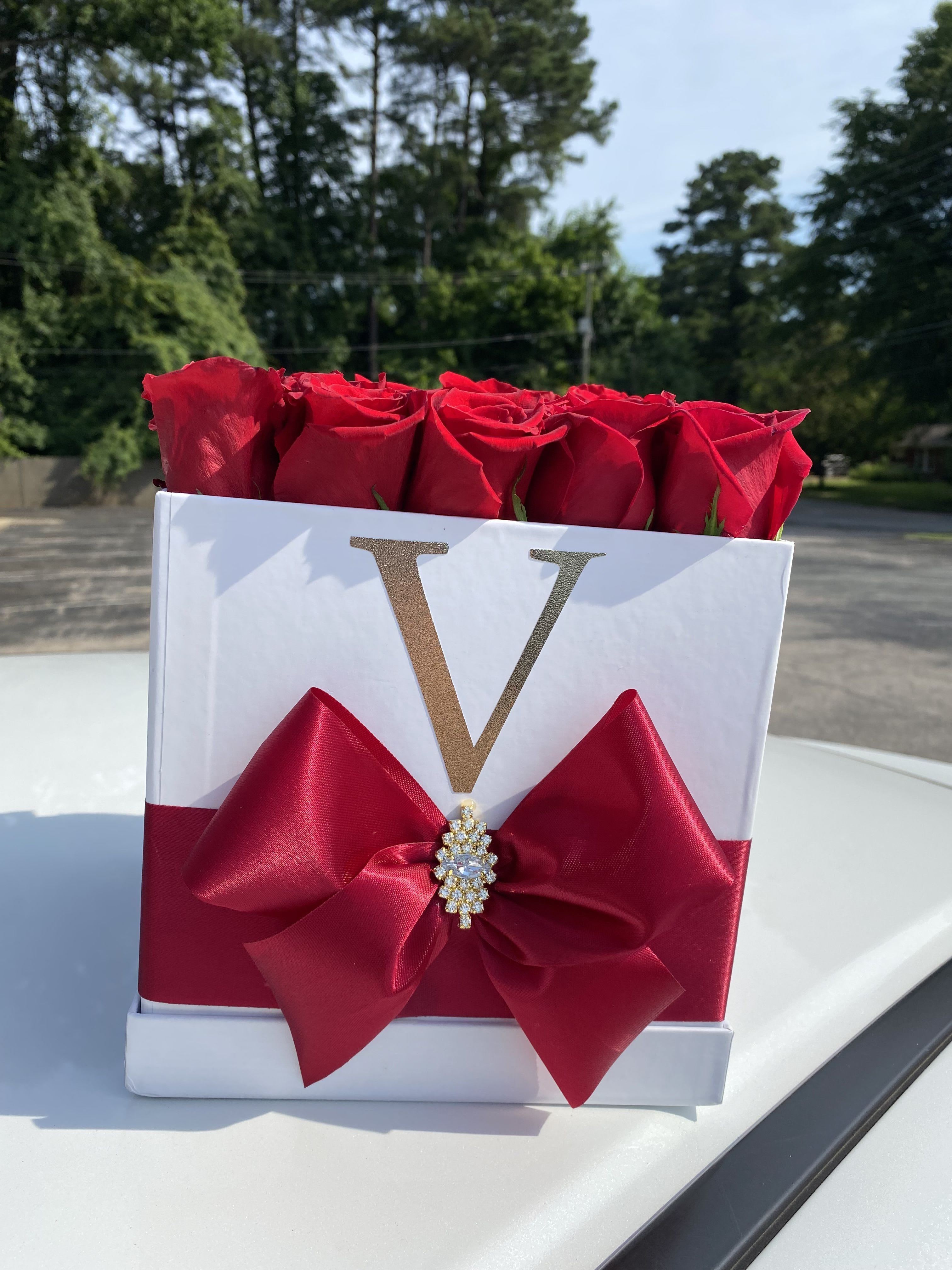 Red roses in a white gift box with a large red bow