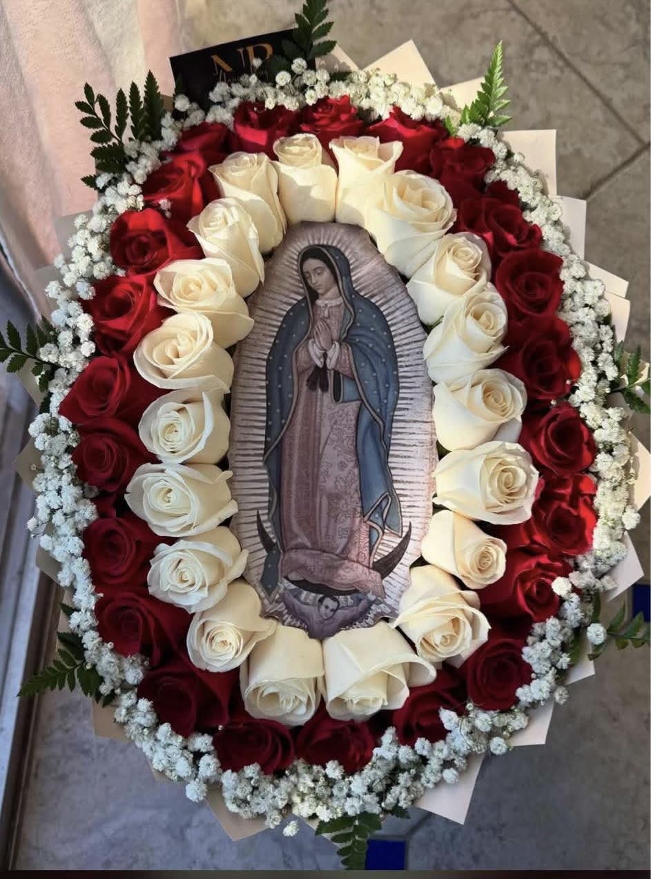 Oval bouquet of red and white roses around a religious image