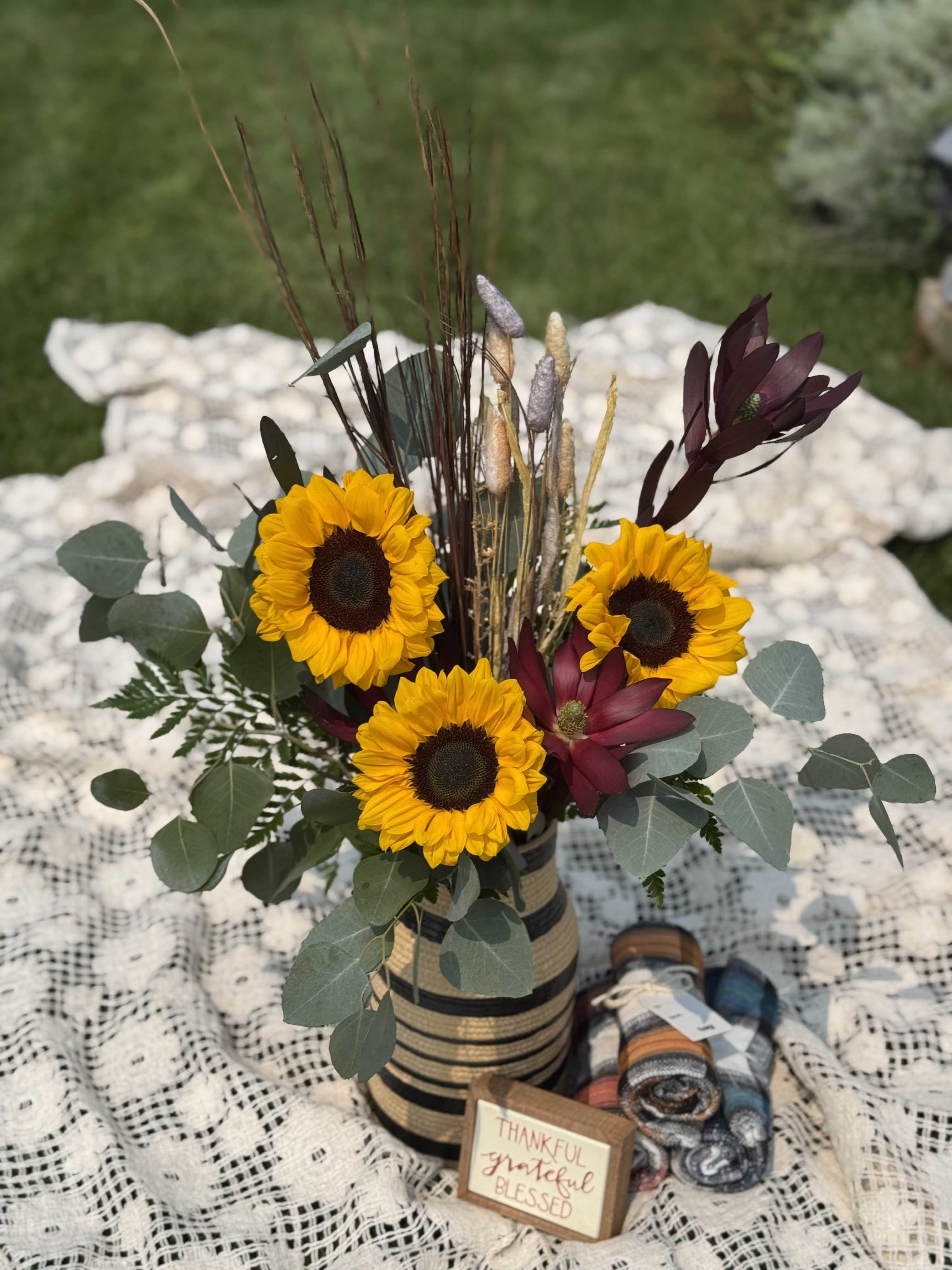 Autumn Harvest - The sunflowers are the star of show in Autumn Harvest.  Set in a large premium vase that you will want to use in your everyday decor, this arrangement is great way to say 'thank you', 'happy anniversary' or just because.  Approximate height is 24"