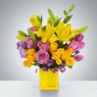 Sunday Afternoon by BloomNation™ - This arrangement is a sweet surprise for any recipient. Featuring a selection of yellow and purple flowers in a yellow vase, this arrangement is springtime in flower form and a great gift for Easter or Passover.  Approximate Dimensions: 13"D x 16"H