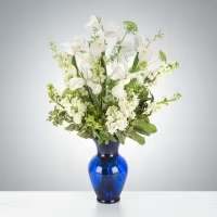 Crystal Symphony by BloomNation™ - This arrangement includes white iris, white stock, white snapdragons, and queen anne's lace in a blue vase. Send your condolences with Crystal Symphony by BloomNation™™.  Approximate Dimensions: 22"D x 30"H