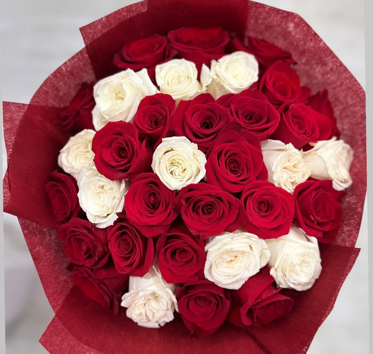 Bouquet of red and white roses wrapped in red paper