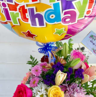 Birthday balloon above a colorful mixed flower bouquet