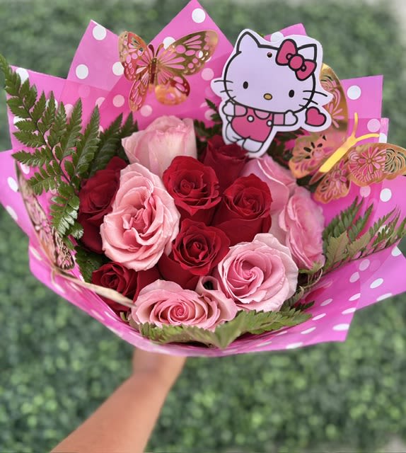 Sweet Kitty Bouquet Ramo - A playful cluster of pink and red roses tied into a rounded hand-tied bouquet that reads like a sweet little celebration - perfect as a birthday bouquet or a "just because" surprise. The Sweet Kitty Bouquet Ramo blends blush and deep red blooms for a romantic-yet-youthful look the person you're thinking of will find charming, whether you're marking a new baby, saying thank you, or sending a flirty spring or summer note.  Tightly clustered roses in shades of pink, red and white sit against fresh green foliage and are wrapped in bright pink polka-dot decorative paper for instant gifting appeal. A Hello Kitty topper and delicate butterfly decoration give the arrangement a whimsical, playful vibe that works for quinceañera, best friends day, or as part of a gift set. Hand-tied and sized to hold comfortably, this bouquet arrives ready to delight - include a short card message at checkout and add care instructions to keep the roses looking fresh for days.