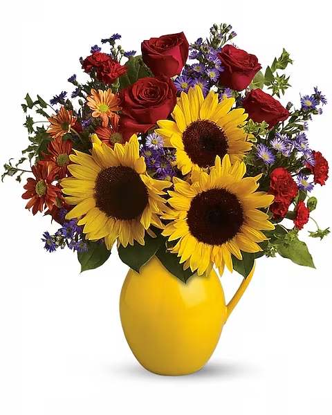Sunflowers, red roses, and purple daisies in a yellow pitcher vase