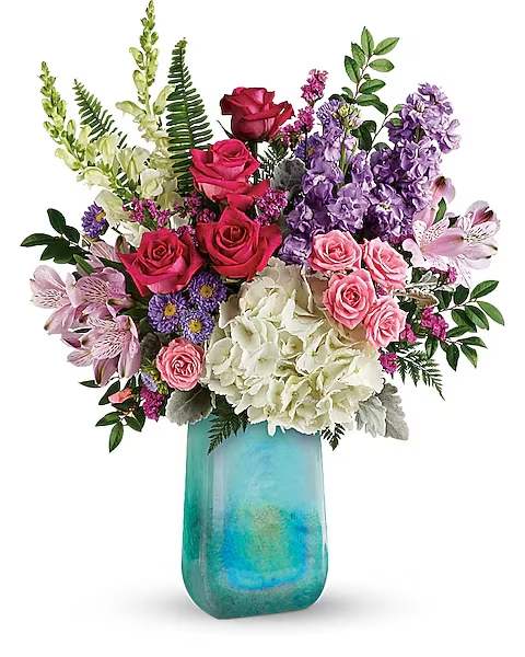 Mixed bouquet of roses, hydrangeas, and purple blooms in a turquoise vase