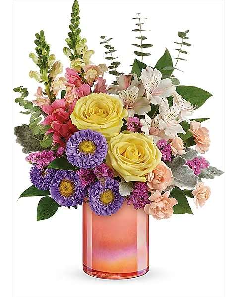 Bouquet of yellow roses, purple daisies, and pink flowers in a pink glass vase