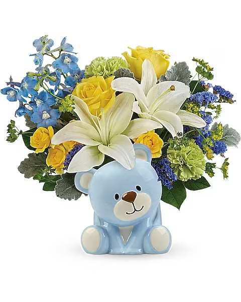 Blue teddy bear with a bouquet of white lilies, yellow roses, and blue flowers